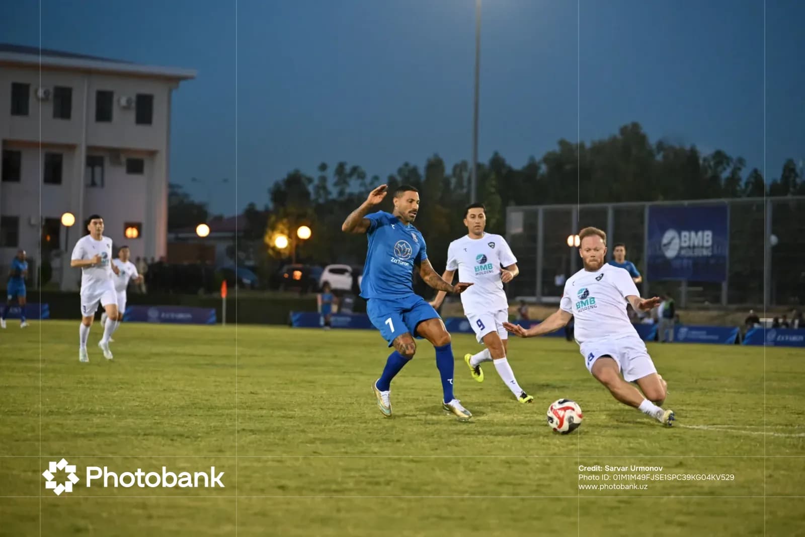 Players compete during a soccer match on a grass field