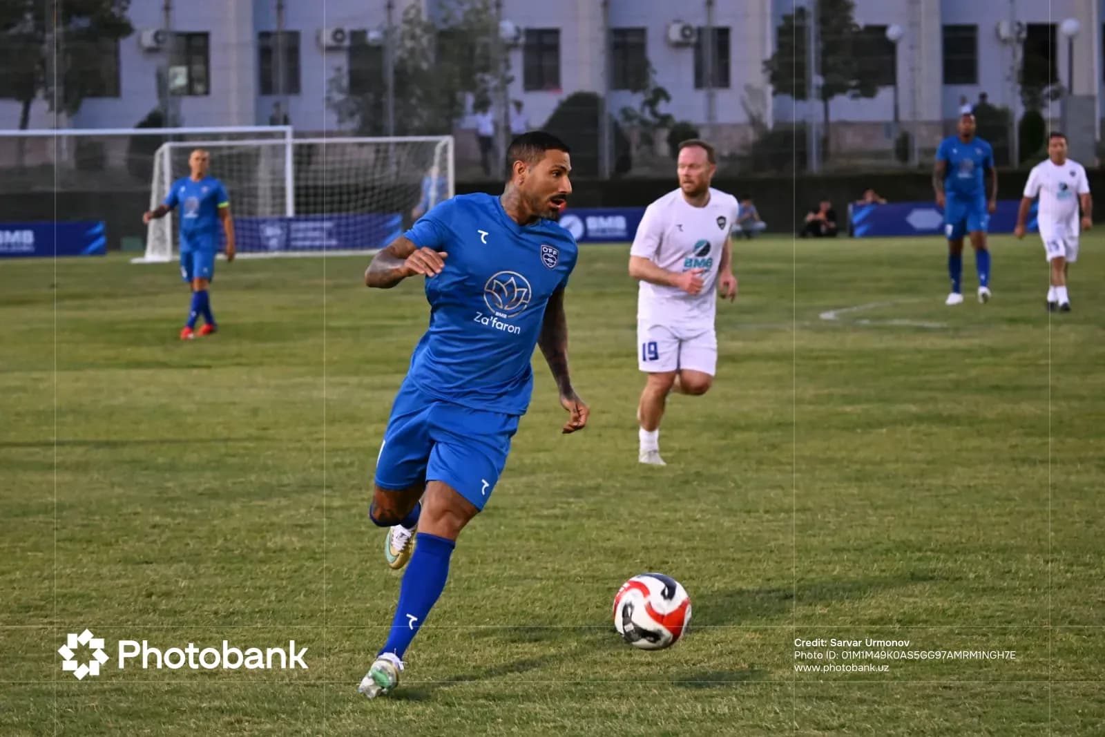 Soccer player running with ball on field
