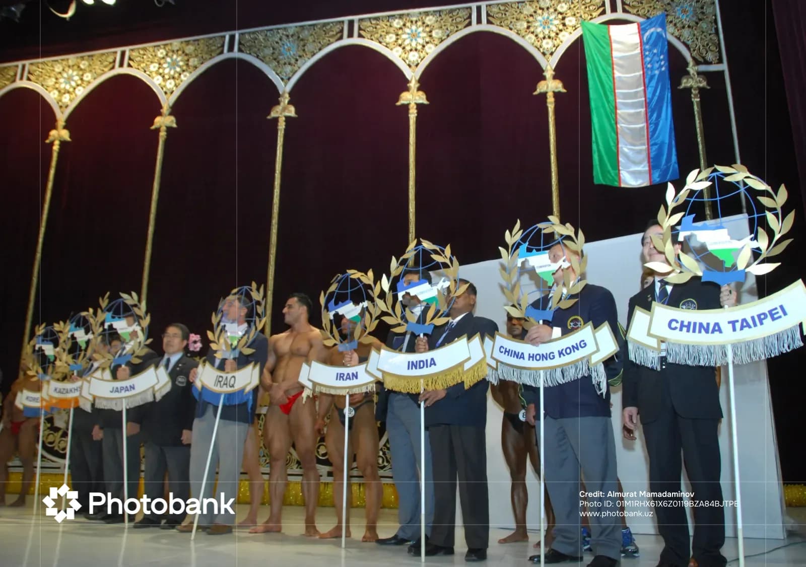 Participants holding country signs and flags on stage