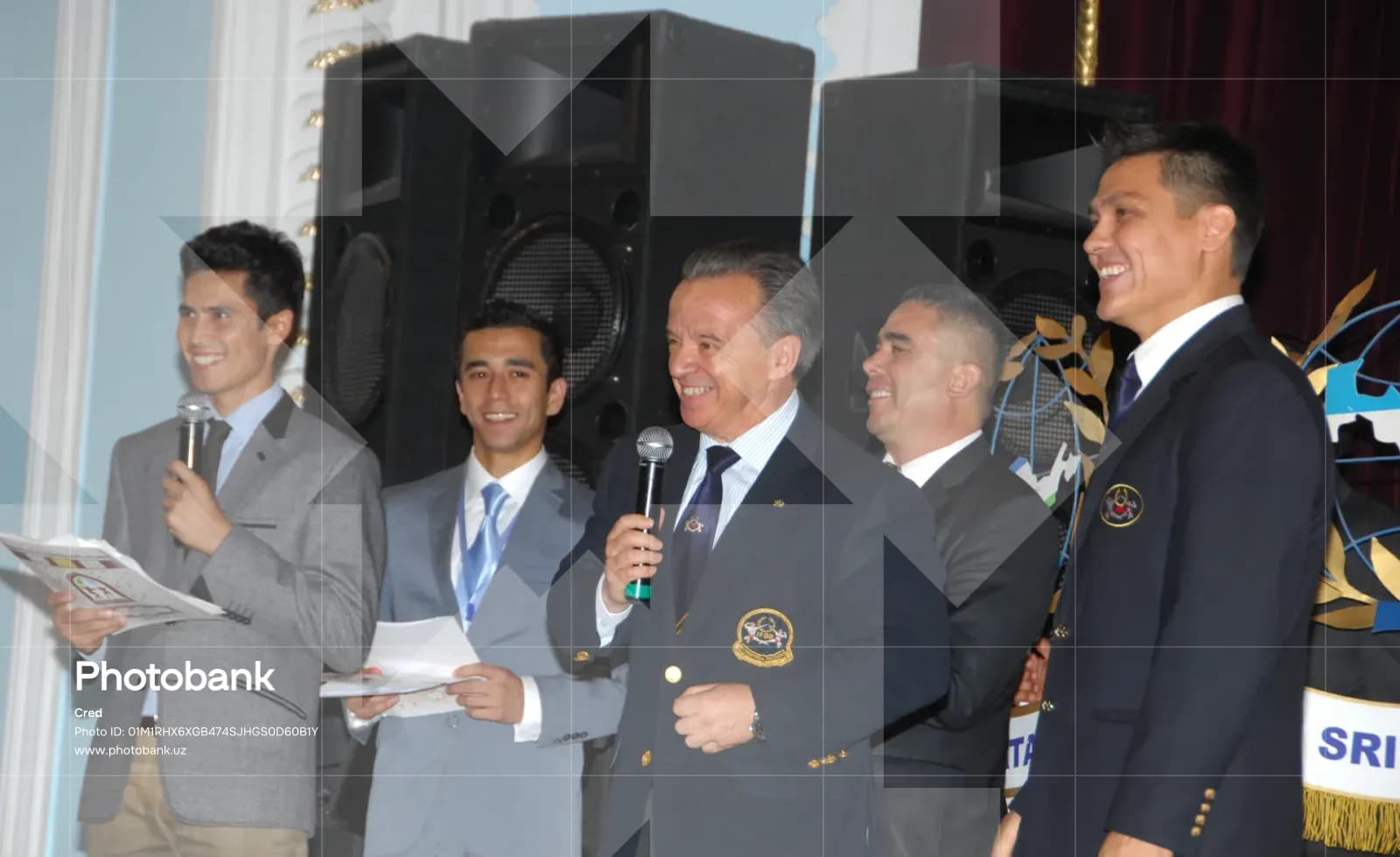 Group of men speaking and smiling on stage