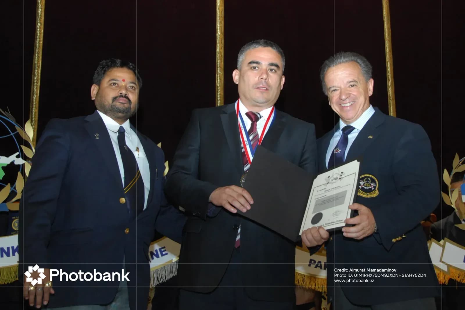 Three men posing with an award certificate