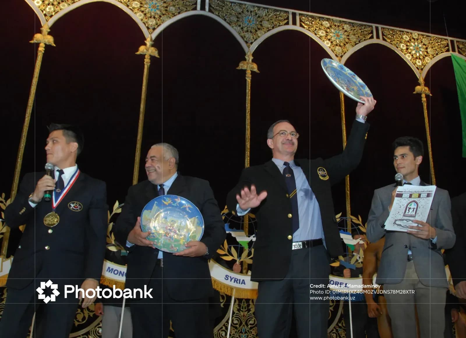 Group of men holding decorative plates on stage
