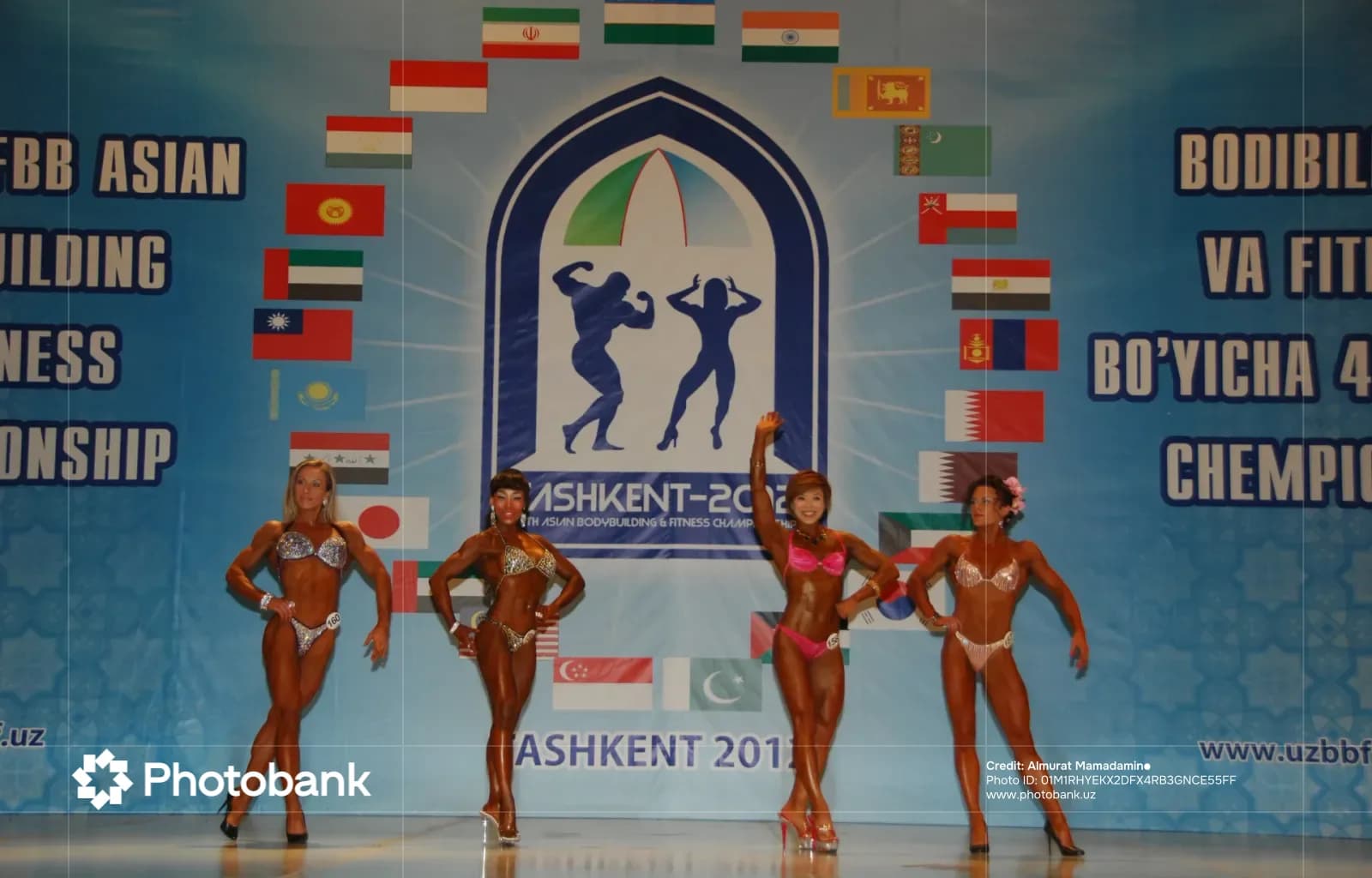 Competitors pose on stage at bodybuilding and fitness championship
