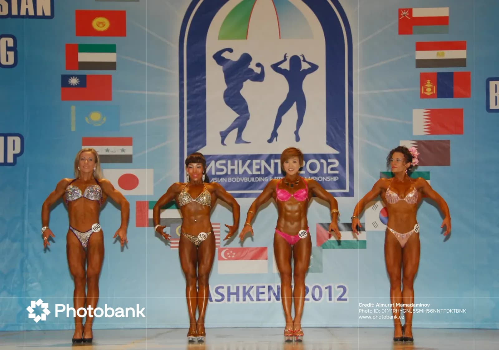 Female athletes posing on stage during a bodybuilding and fitness competition