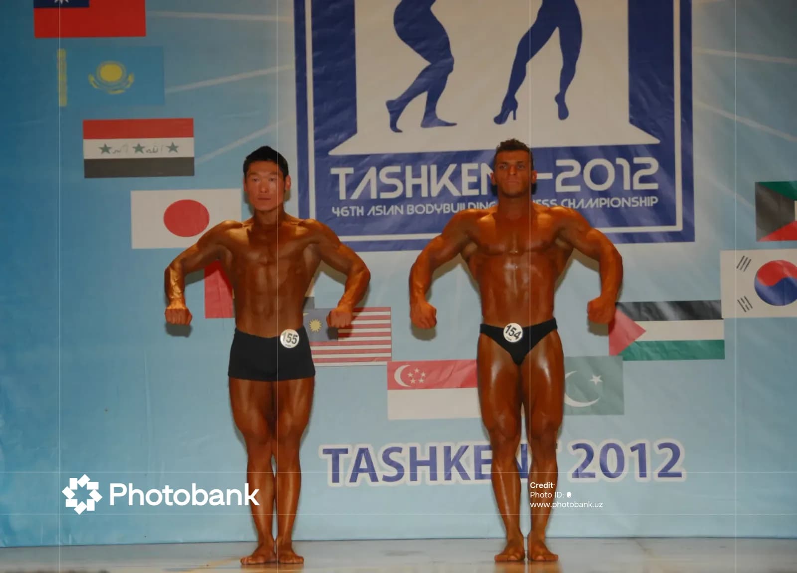 Bodybuilders pose on stage during competition