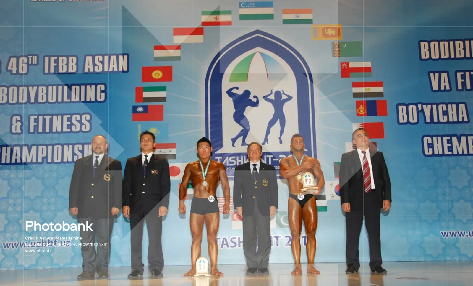 Athletes and officials pose on stage during a bodybuilding championship
