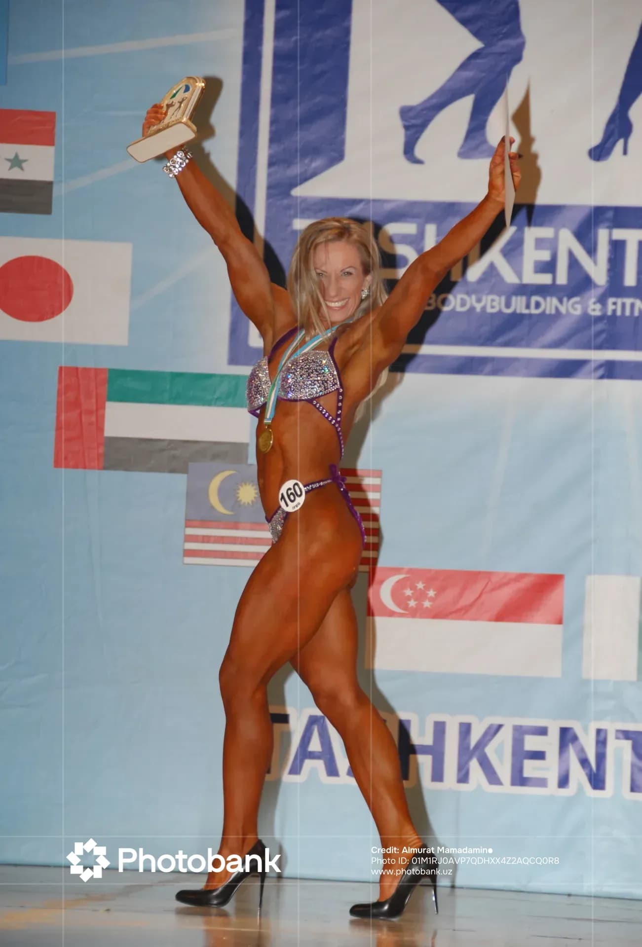 Female athlete holding a trophy on stage