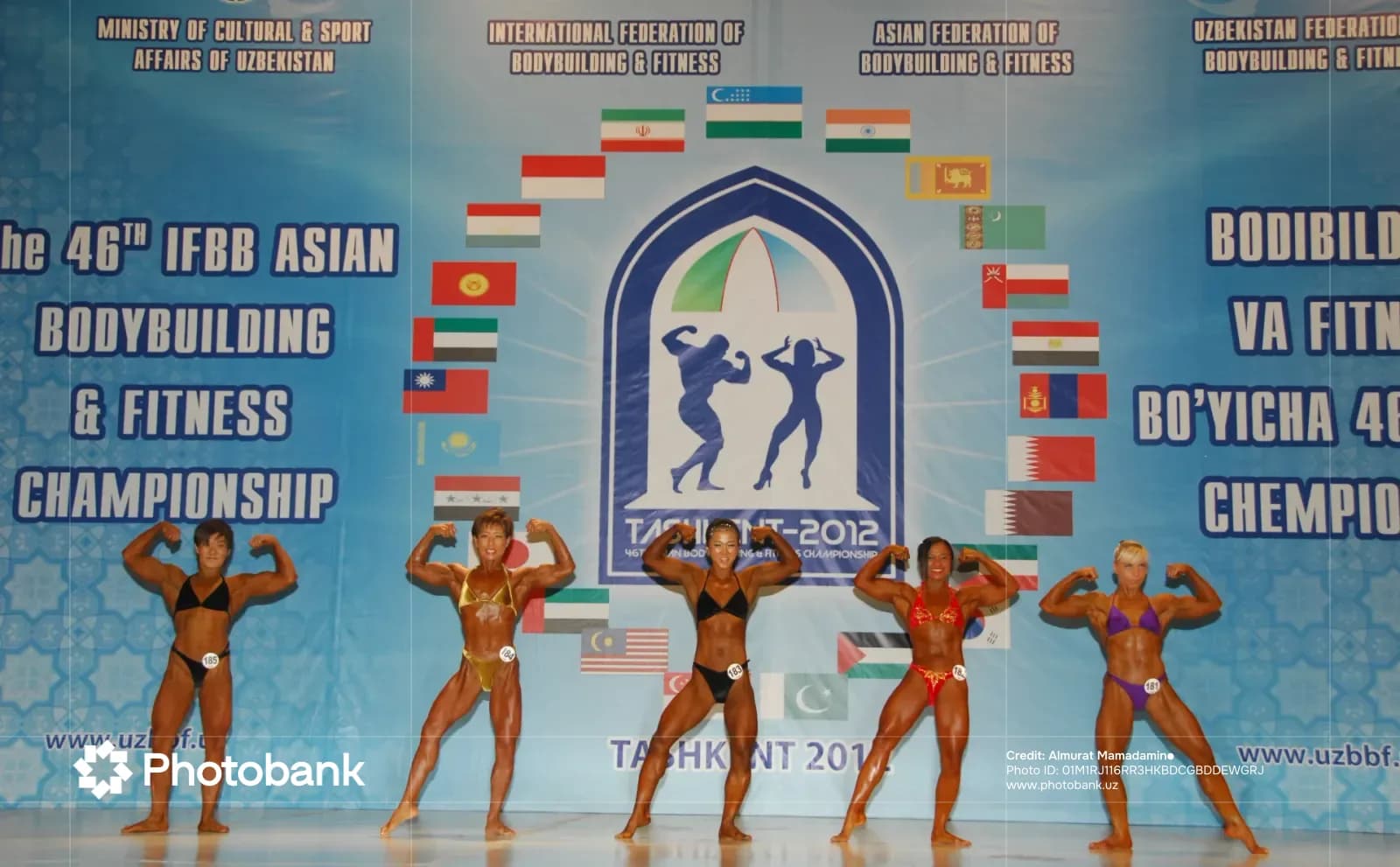 Athletes pose on stage during bodybuilding competition