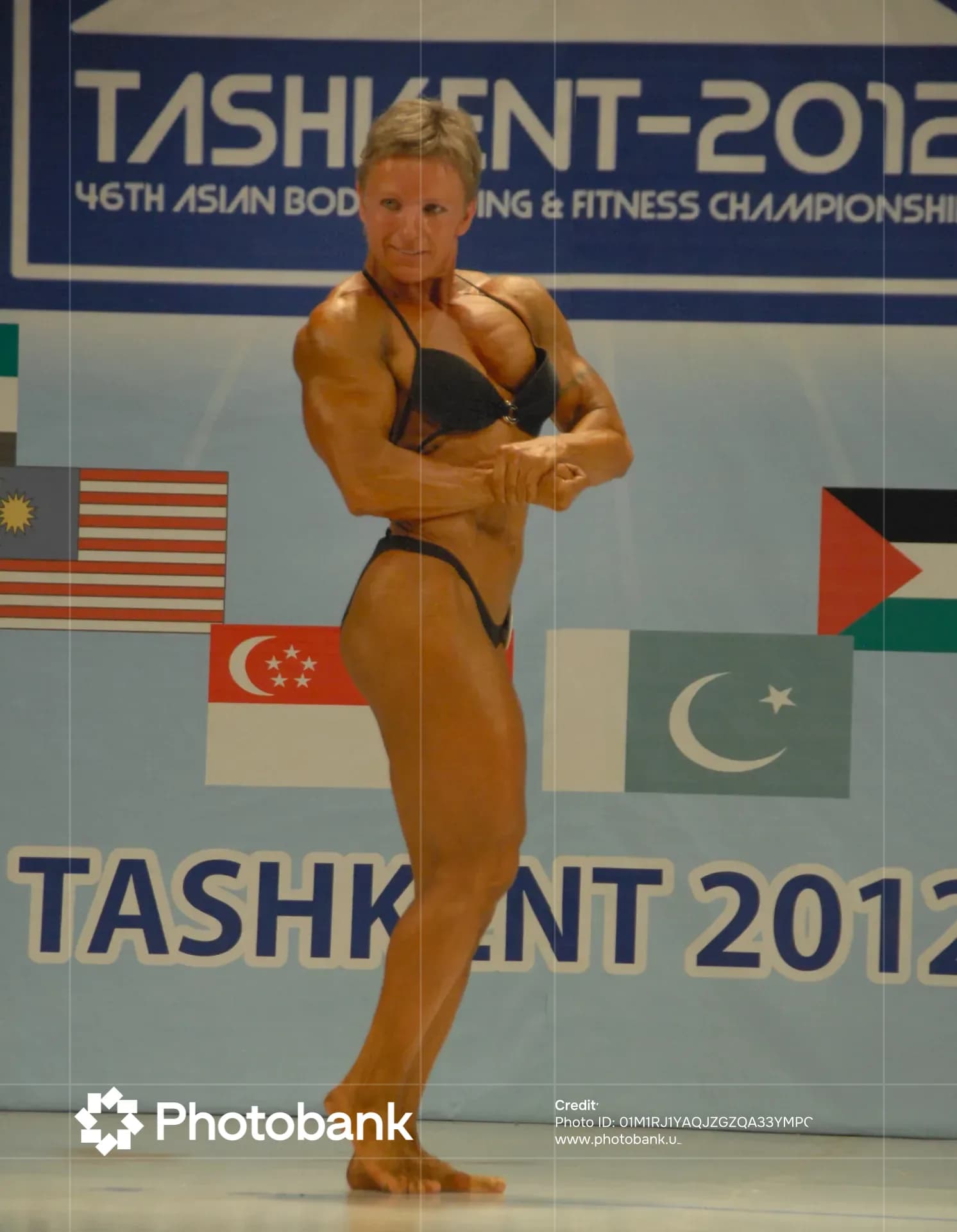 Female athlete posing at bodybuilding competition in Tashkent