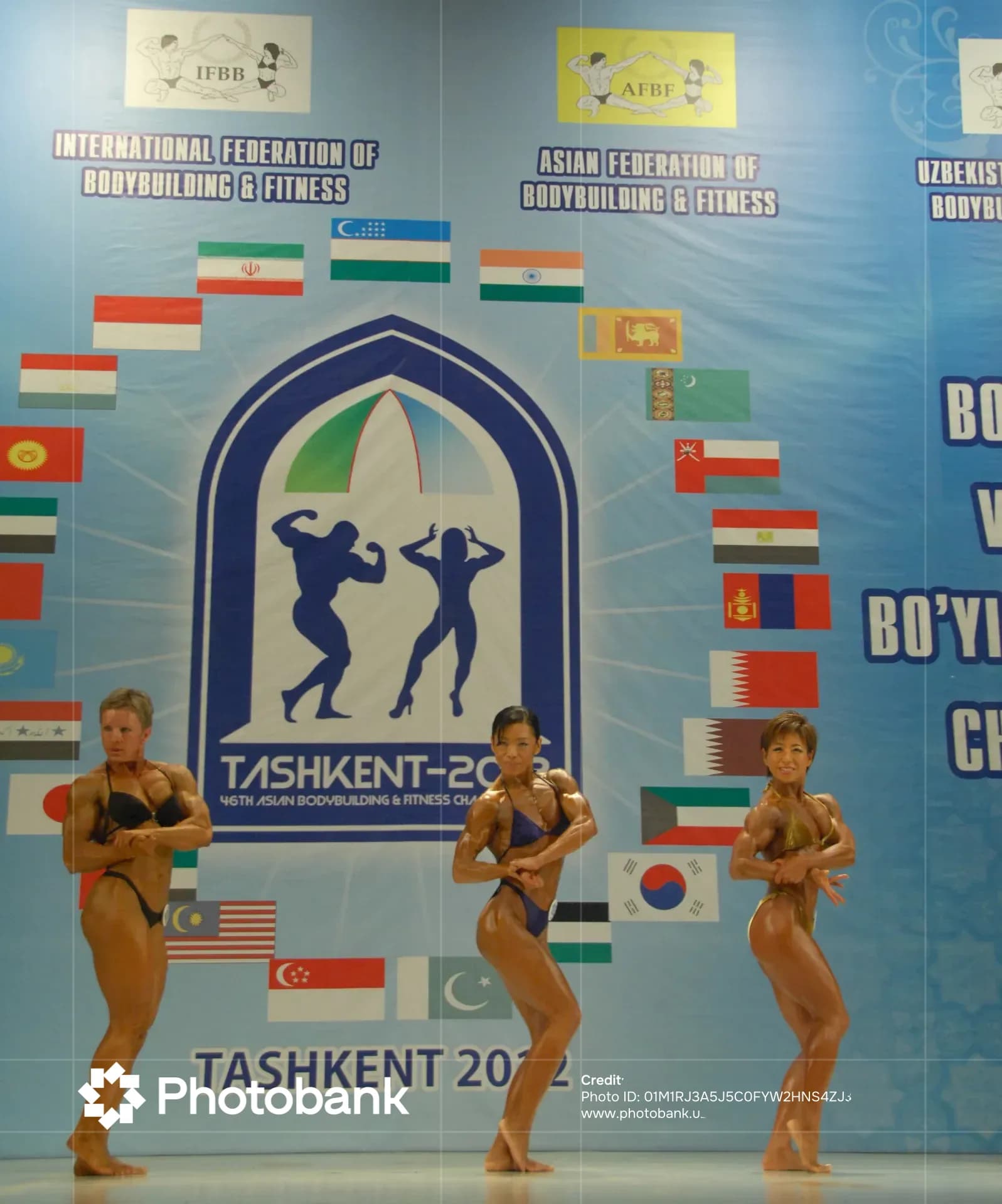 Female bodybuilders posing on stage at a competition
