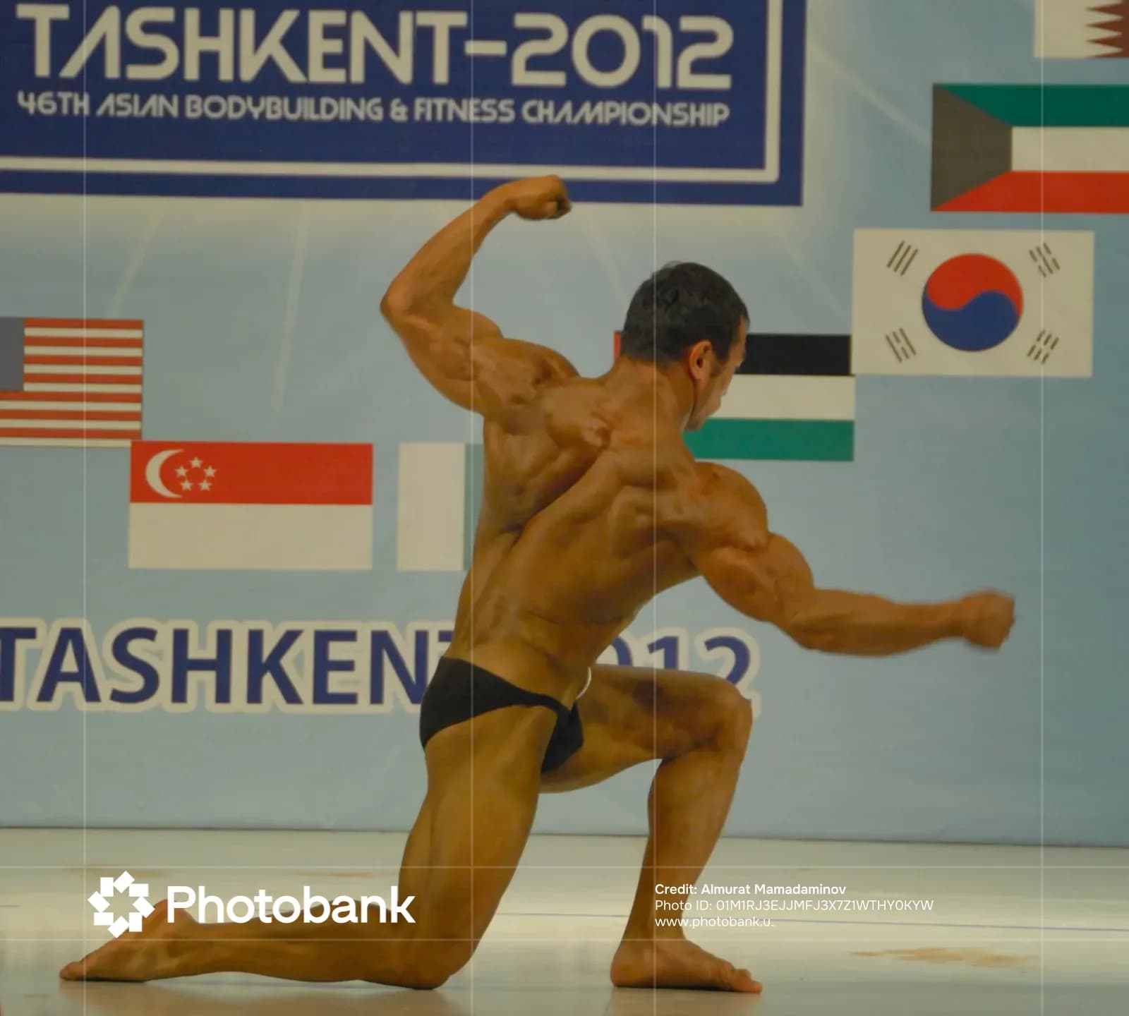 Bodybuilder performs on stage during competition
