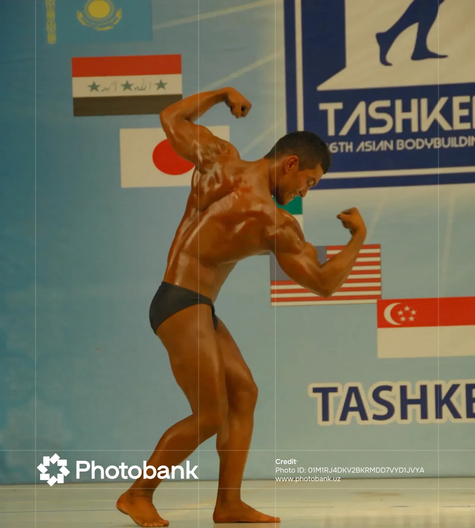 Bodybuilder performs a pose on stage during a competition