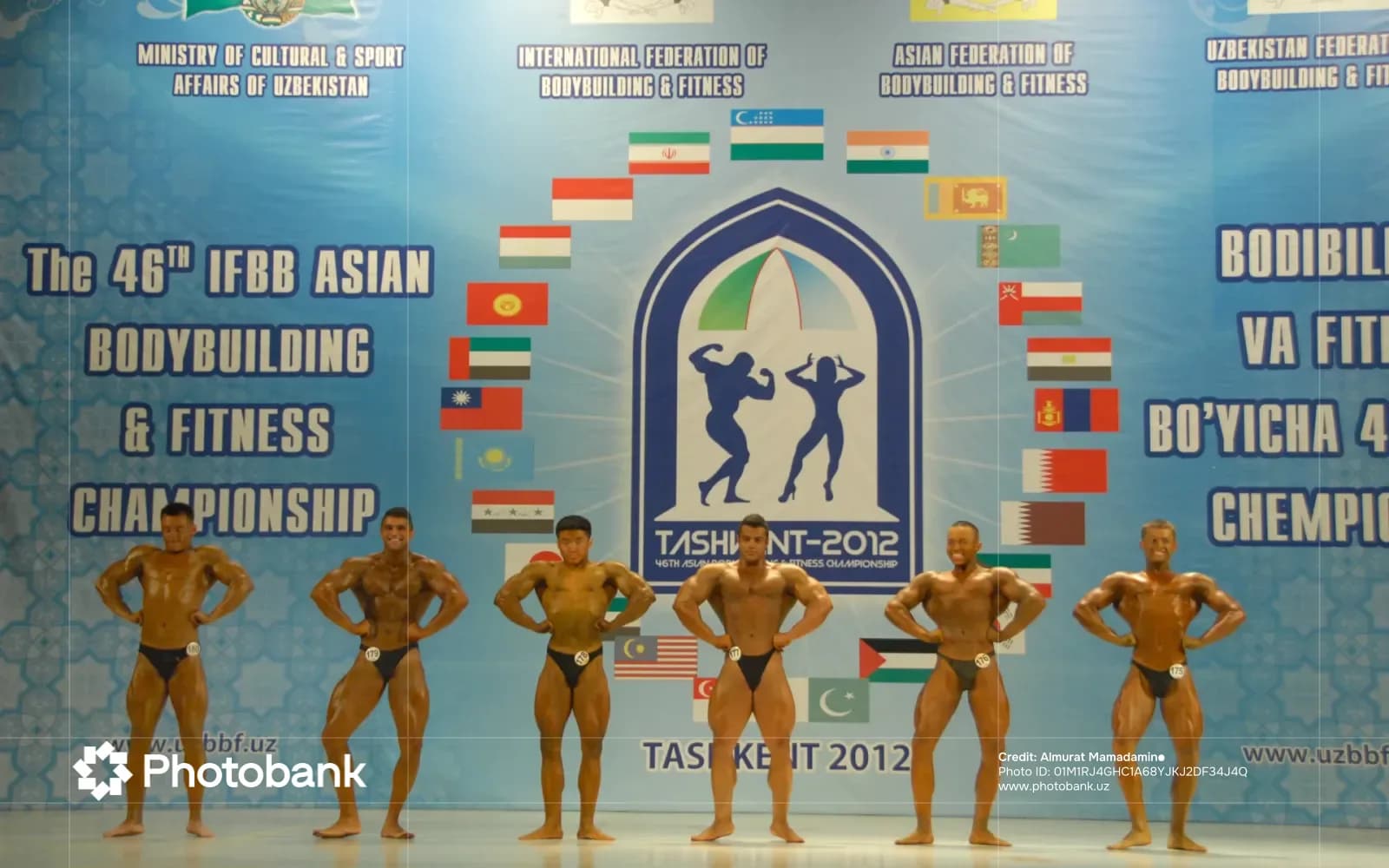 Bodybuilders pose on stage during a competition