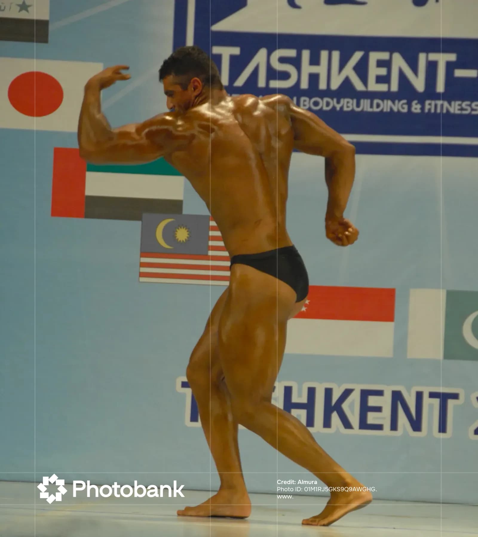 Athlete poses on stage during competition