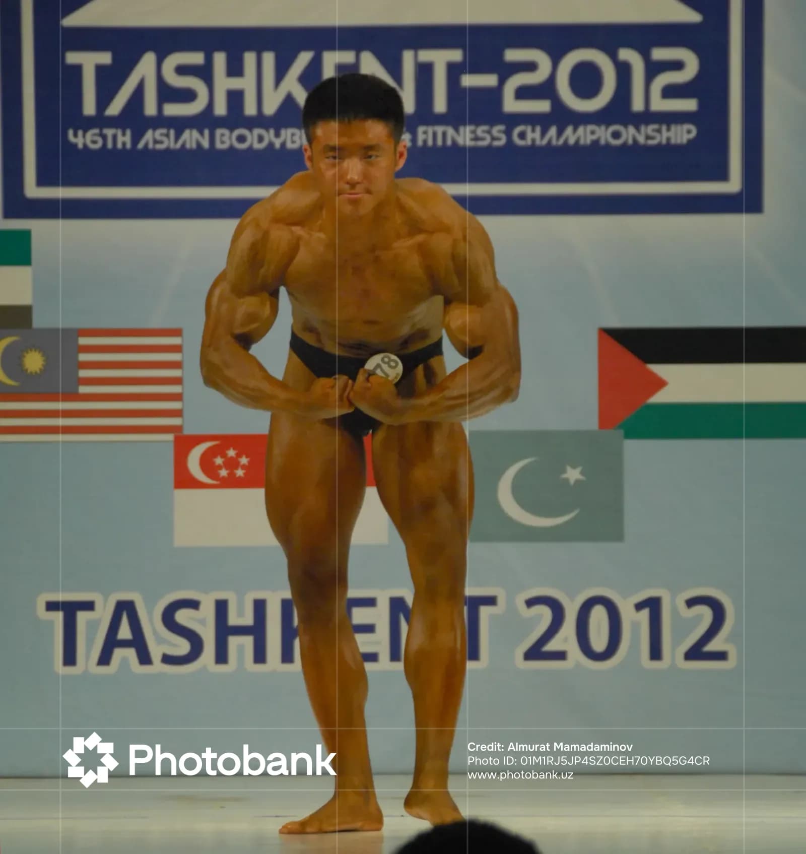Athlete poses on stage during competition
