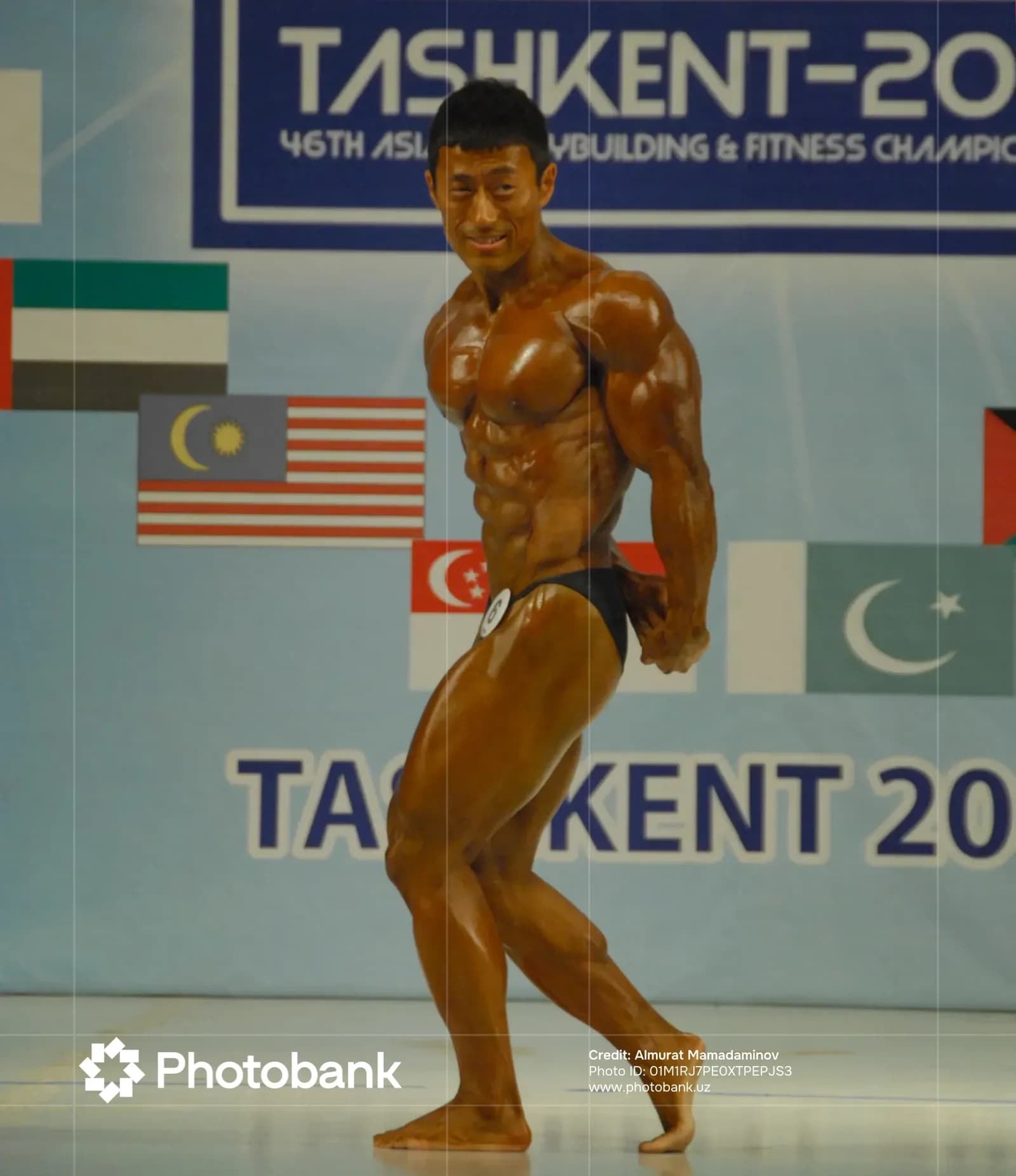 Athlete poses on stage during competition