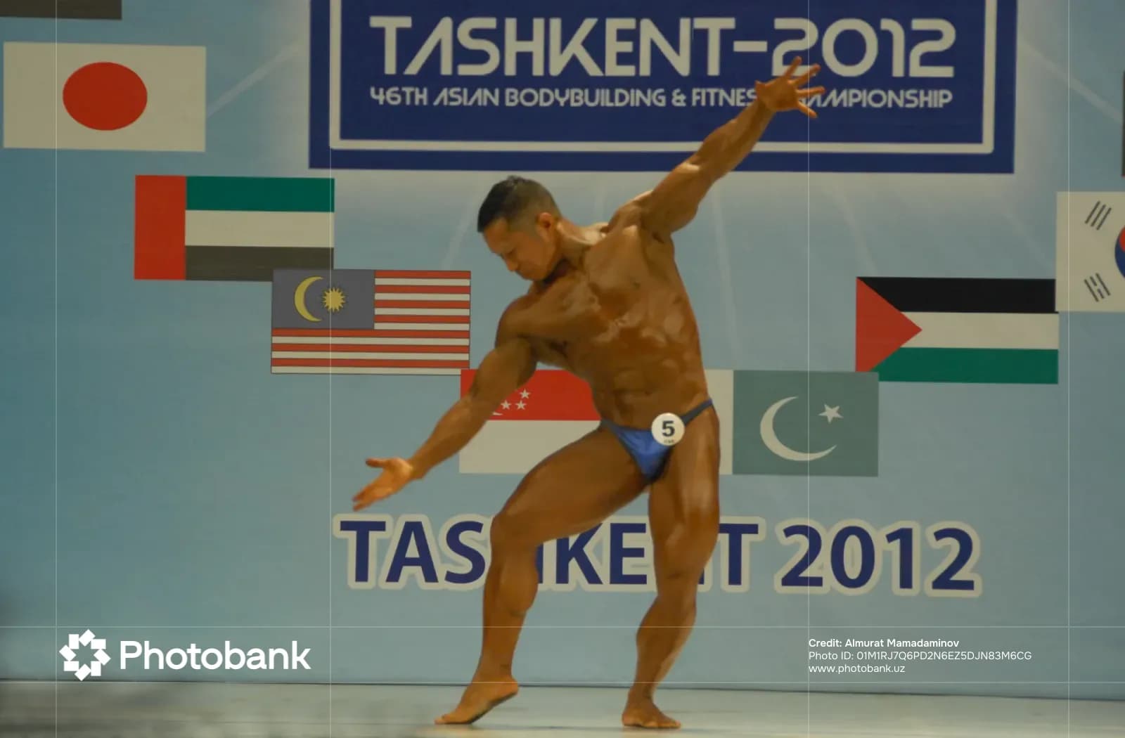 Bodybuilder posing on stage at a sports competition