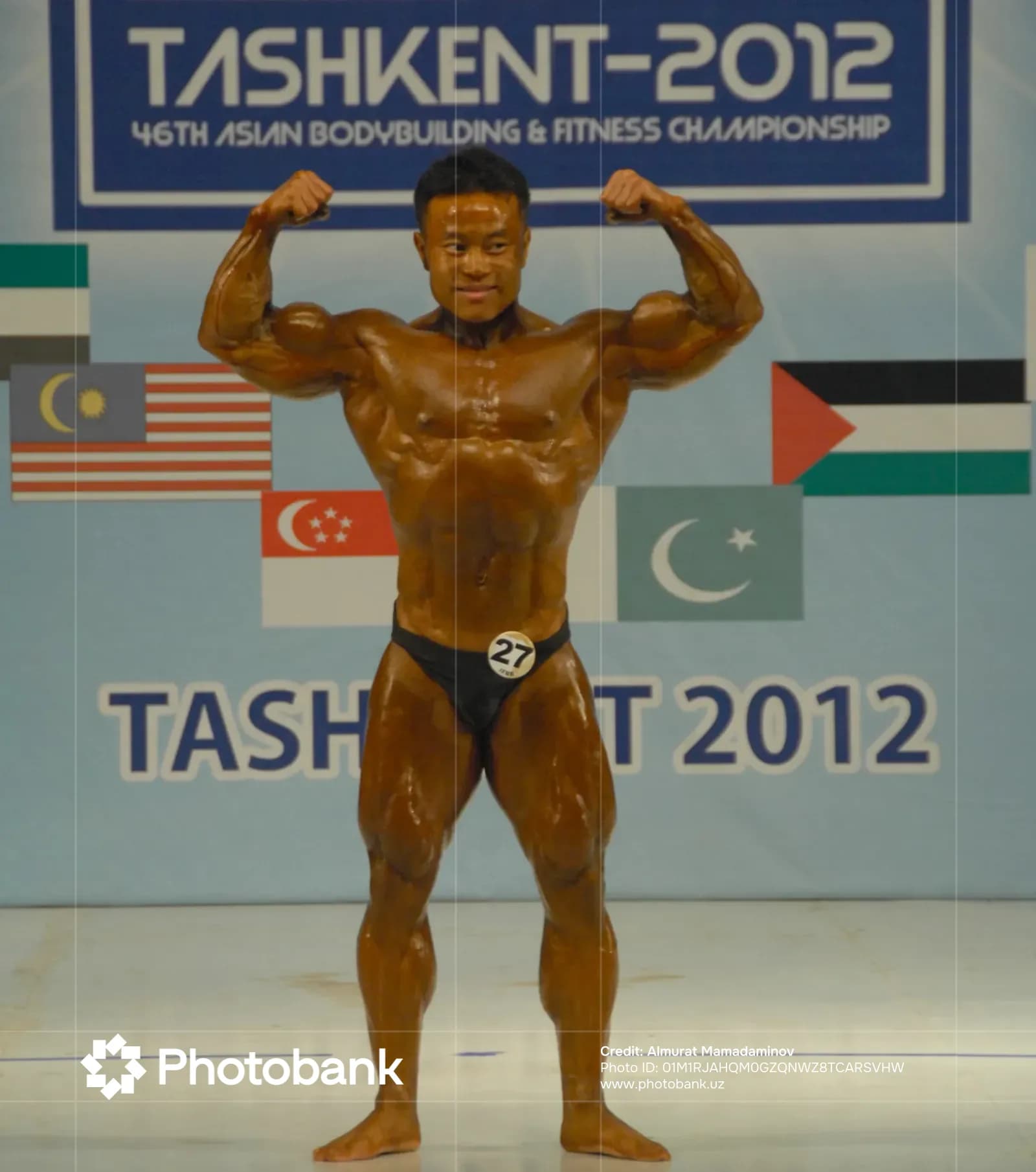 Bodybuilder flexing muscles on stage