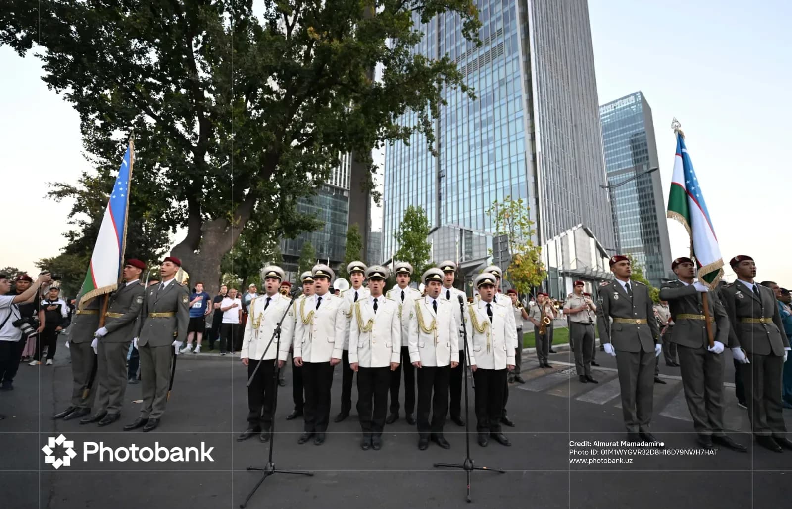 People in uniform singing with flags outdoors