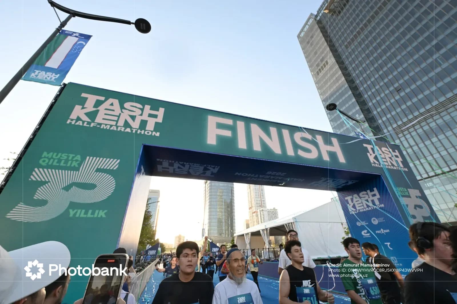 People running past a finish line arch