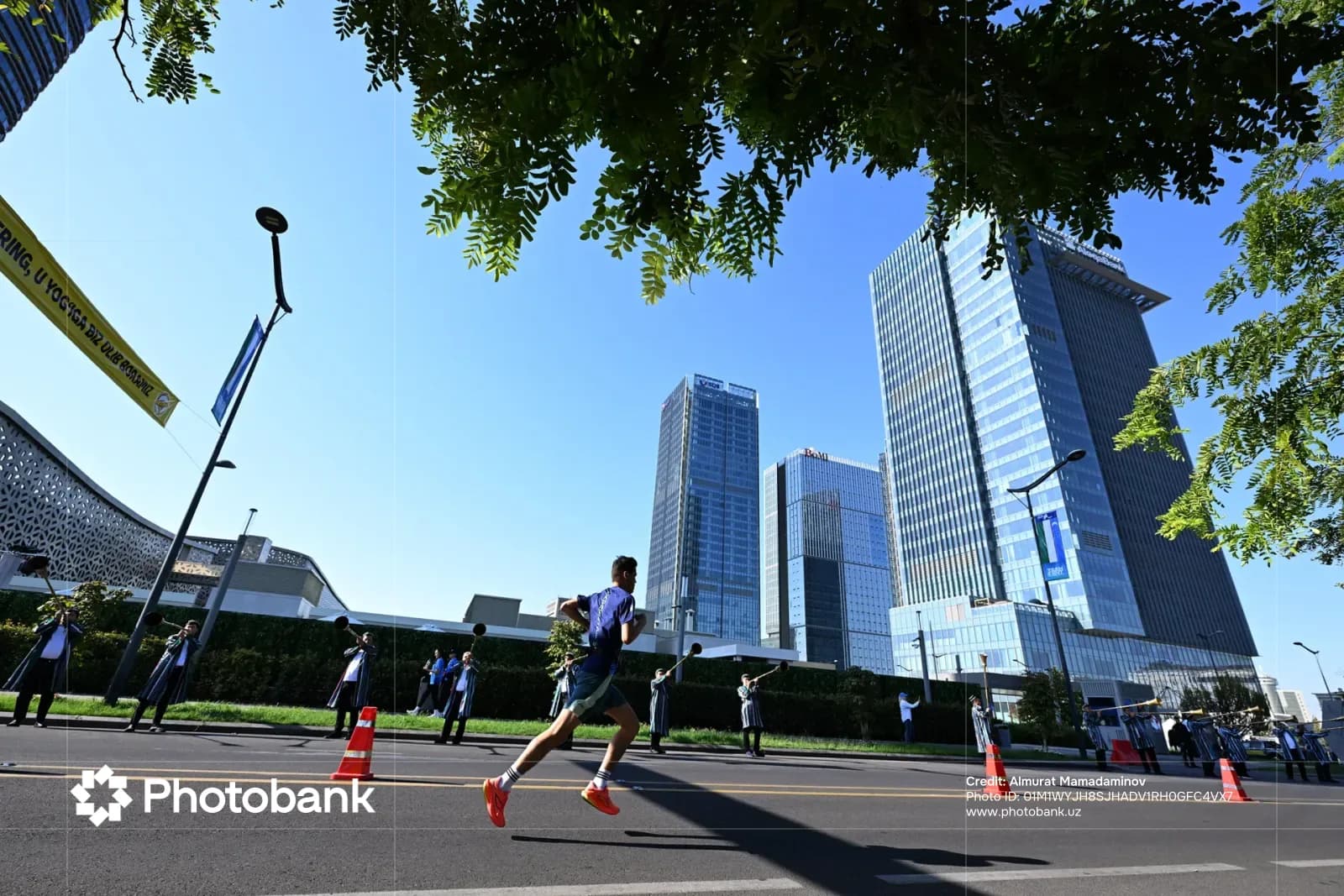 Person running along city street past high-rise buildings