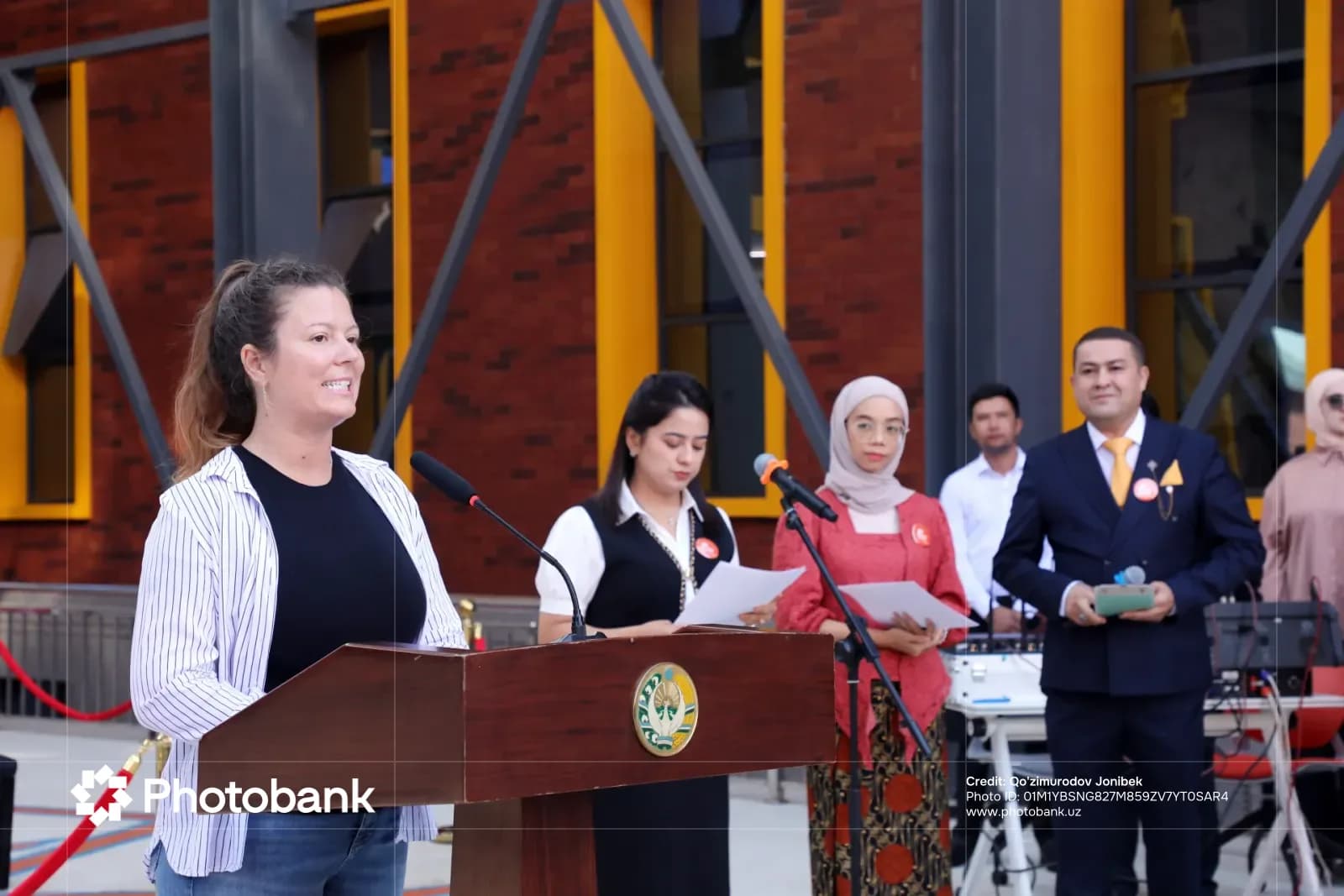 Woman speaking at a podium outdoors