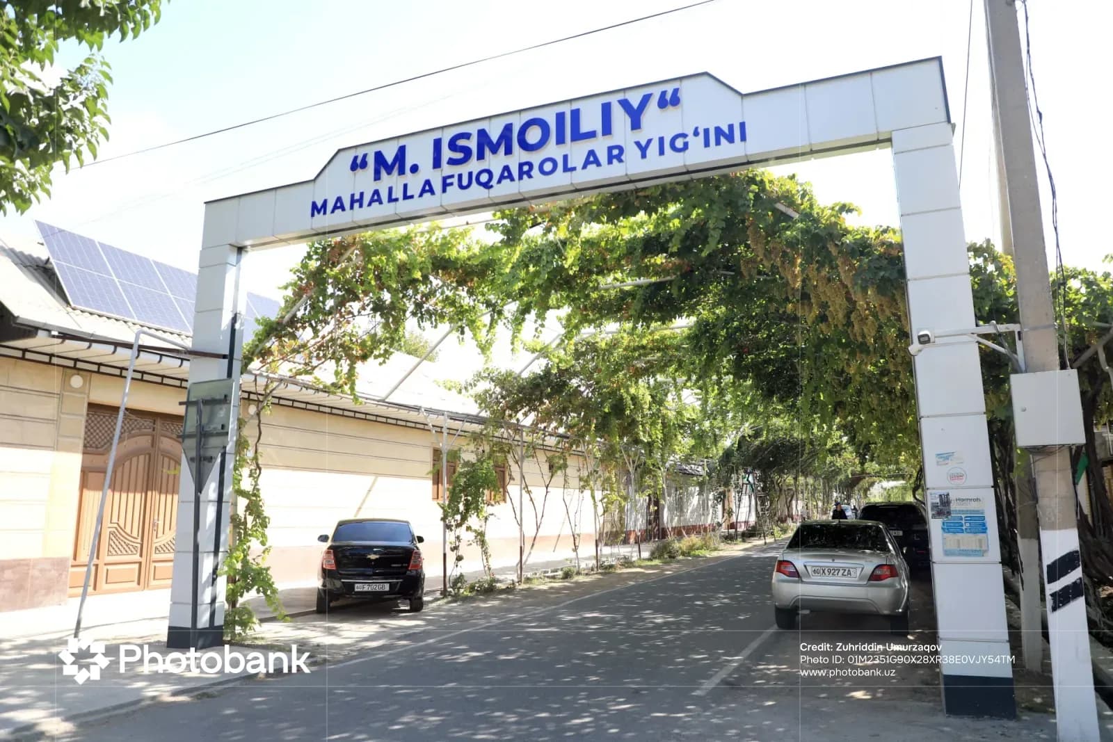 Street view featuring an arched entrance structure with text