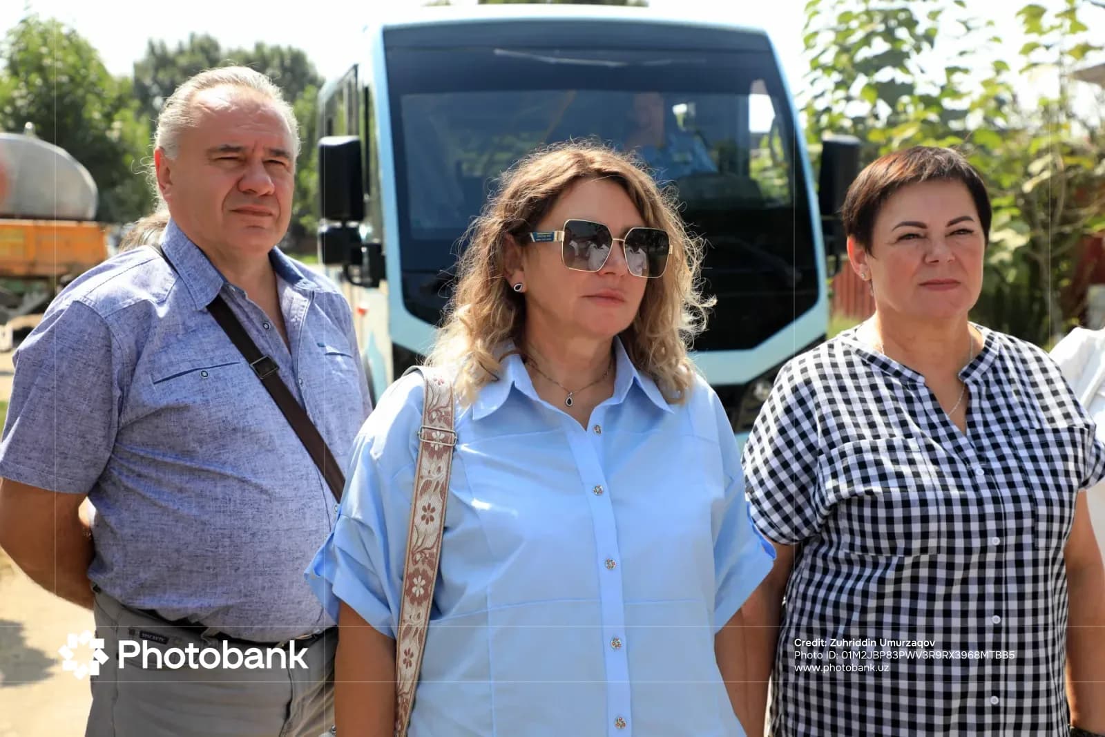 Три человека стоят снаружи рядом с автобусом