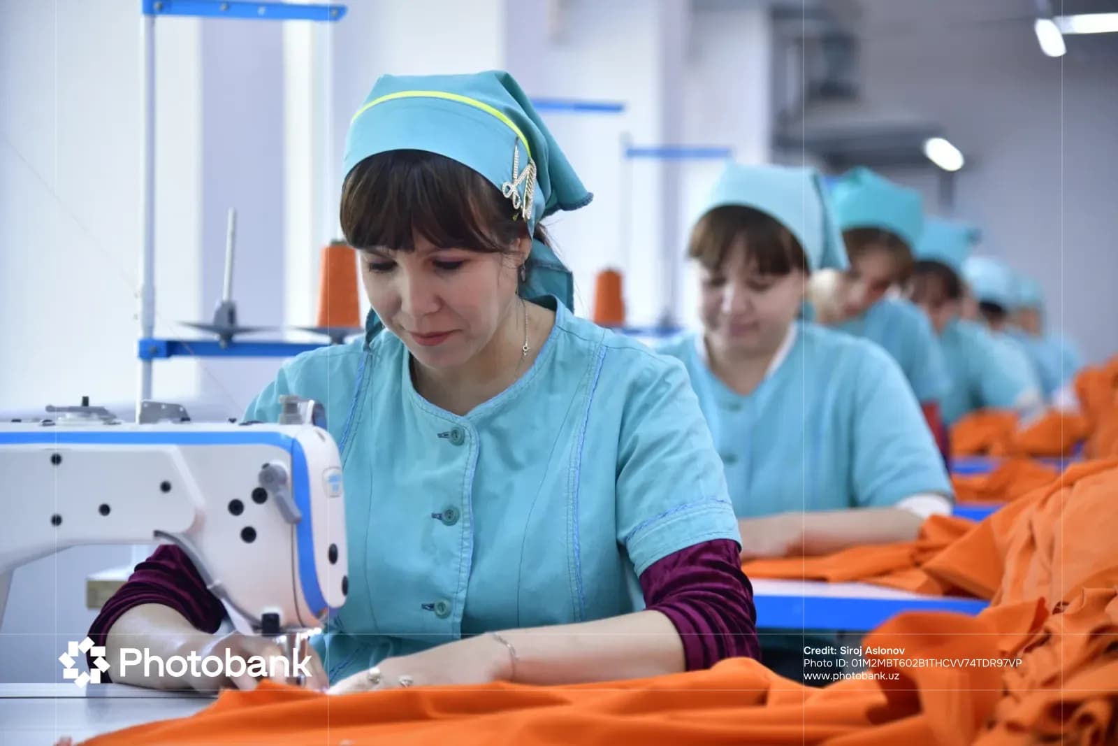 Женщины, работающие на швейных машинах на текстильной фабрике