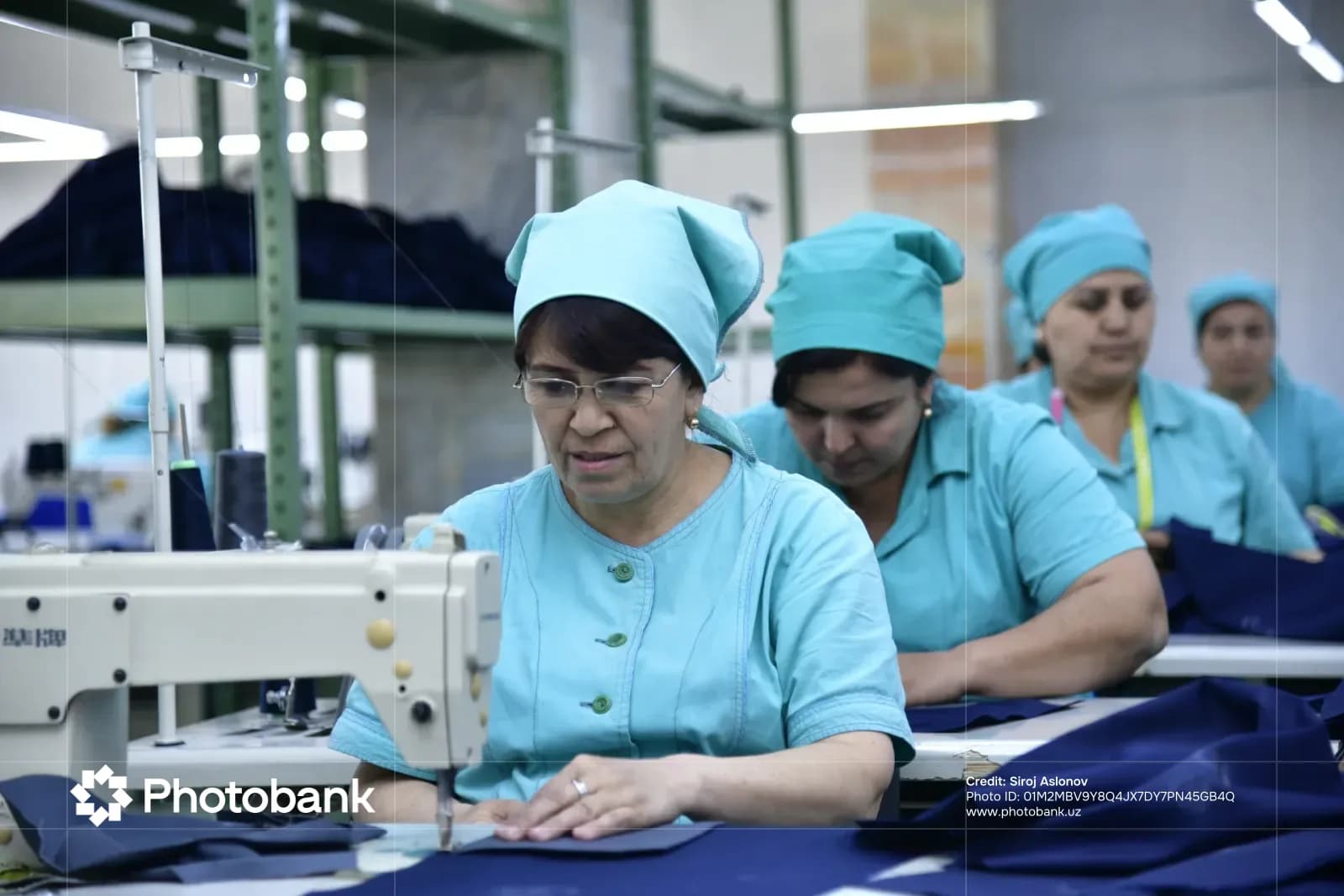 Женщины, работающие на швейных машинах на швейной фабрике