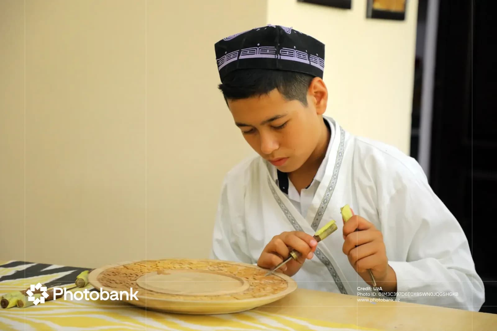 Artisan carving a wooden plate