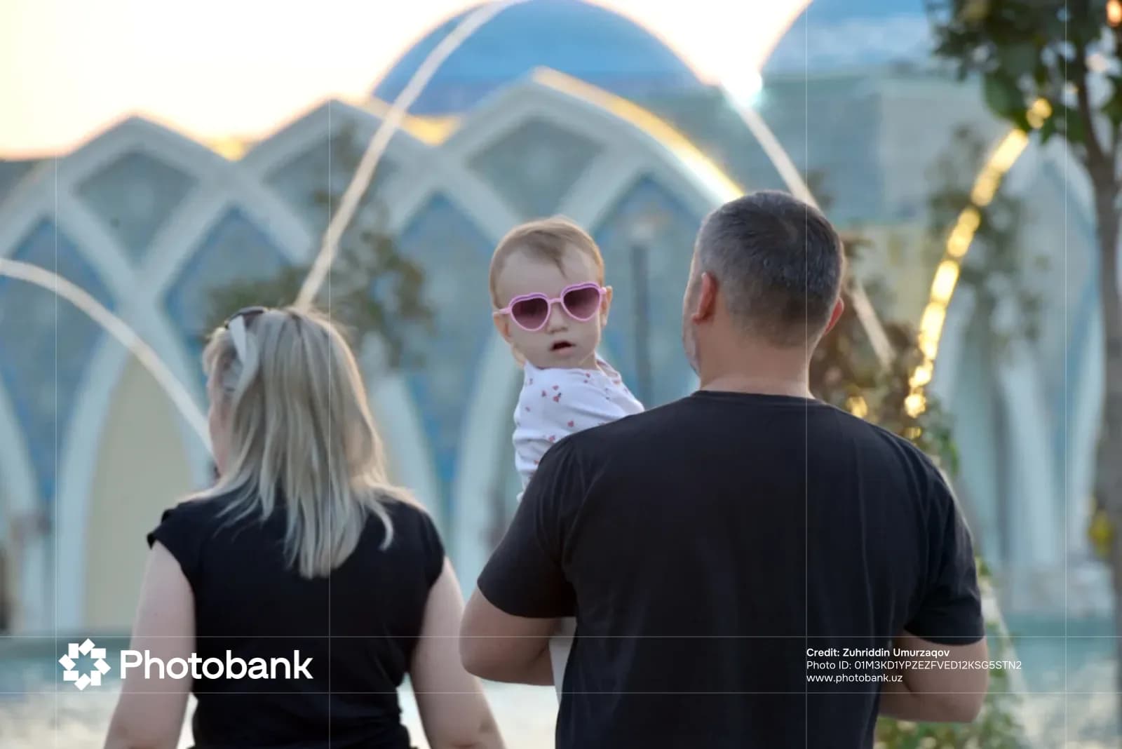 Семья стоит рядом с фонтаном на открытом воздухе