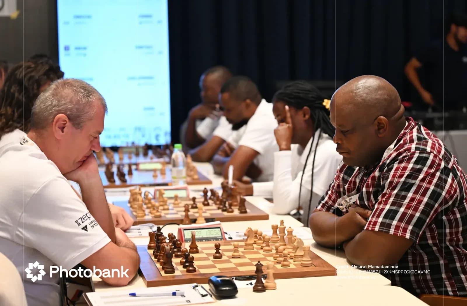 People playing chess at tables in a room