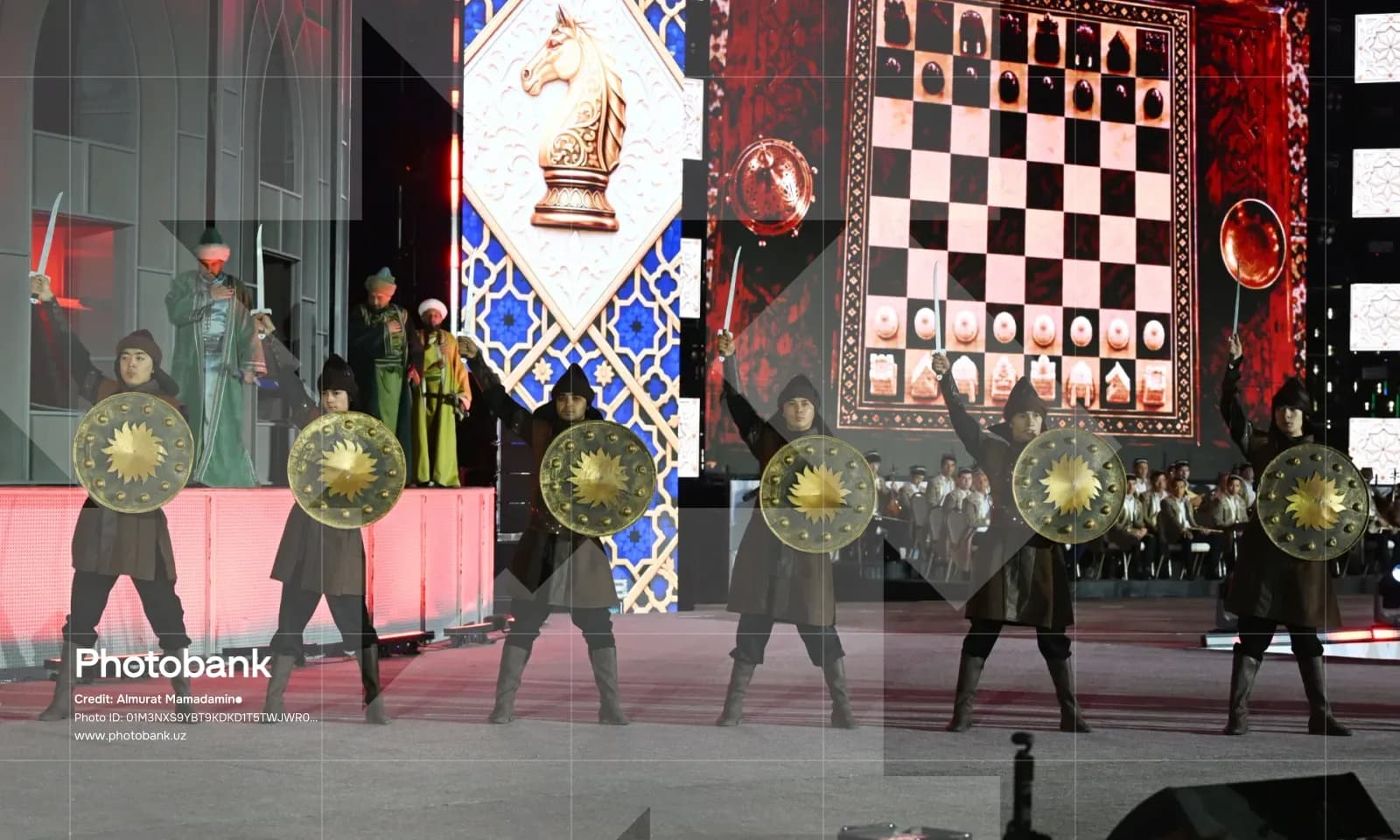 Performers in historical warrior costumes with swords and shields on stage