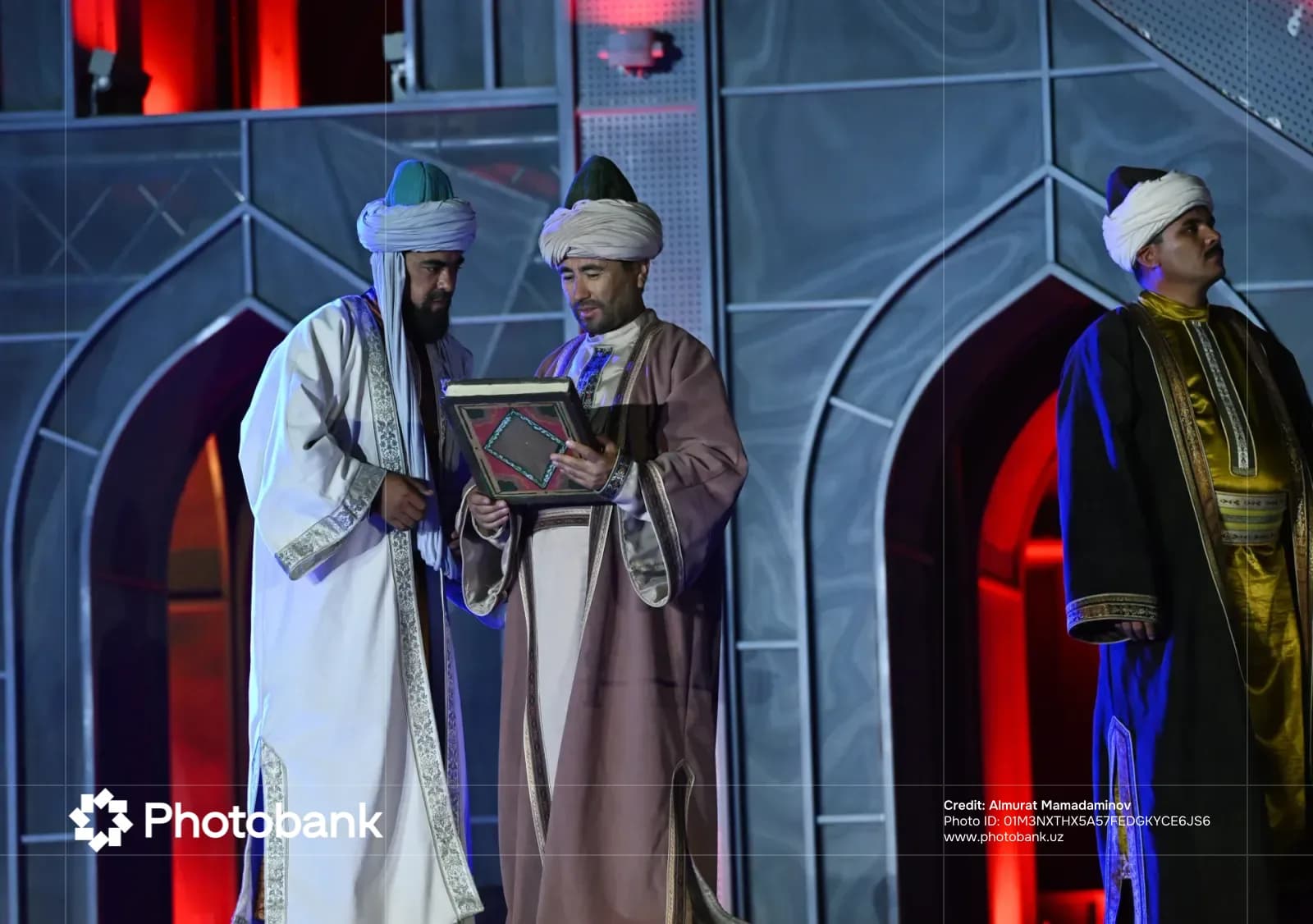 People in traditional historical attire examining a book on stage
