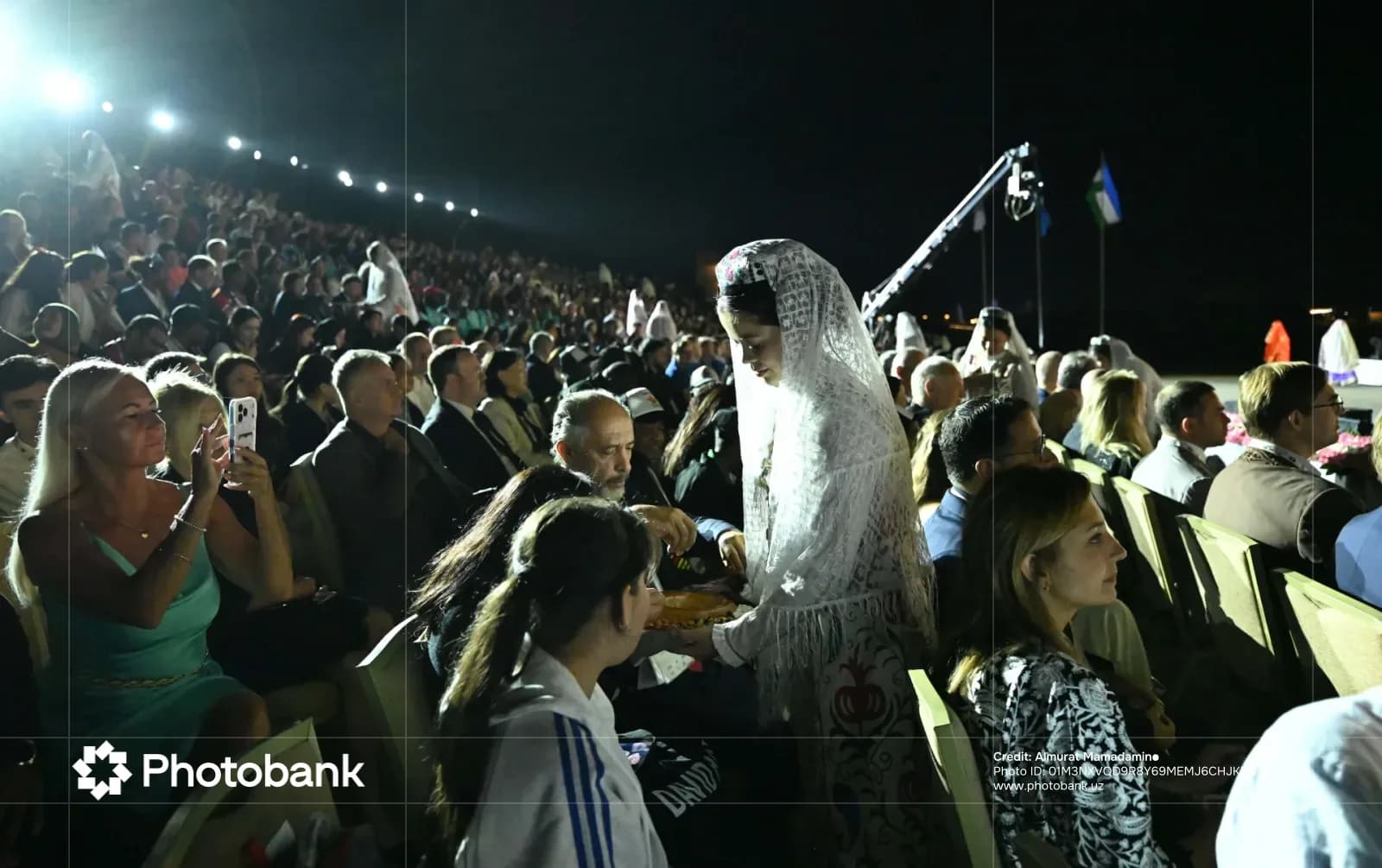 People gathered in an outdoor seated audience at night
