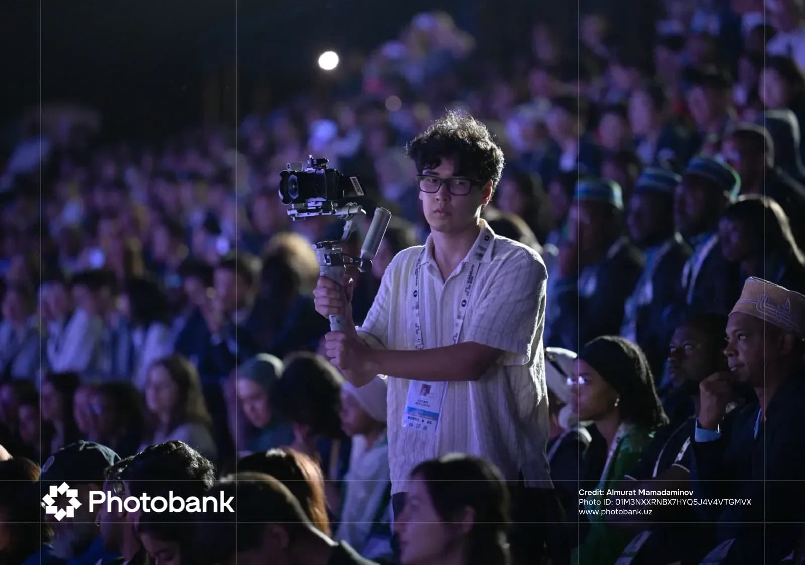 Person recording video with camera in crowd