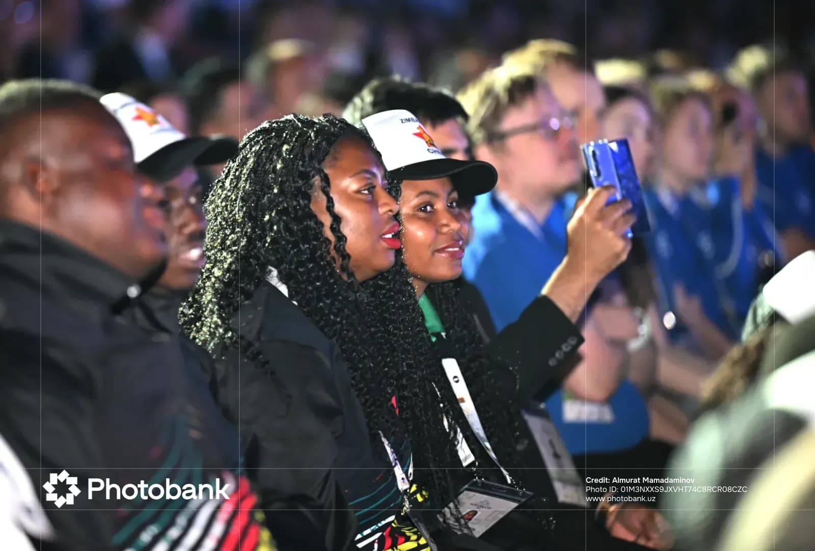 People in audience recording event with mobile phone