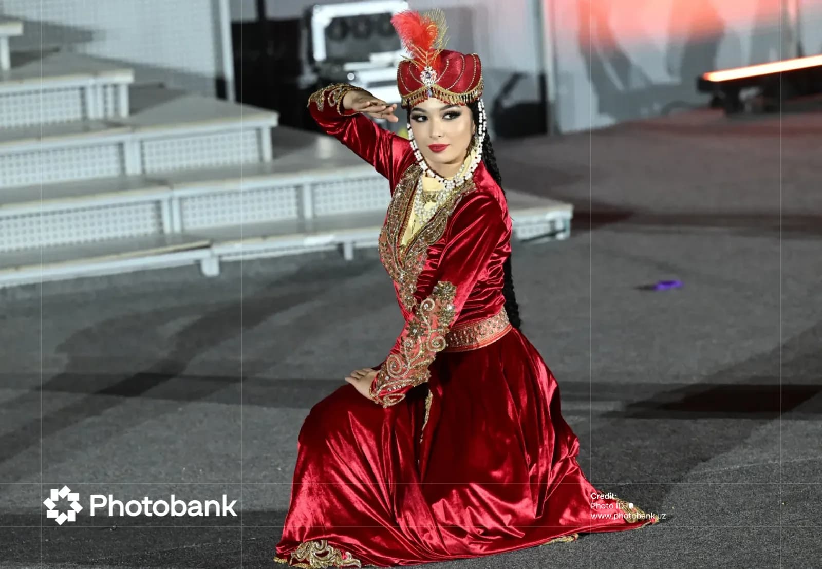 Performer in red dress and ornate headdress performing a traditional dance