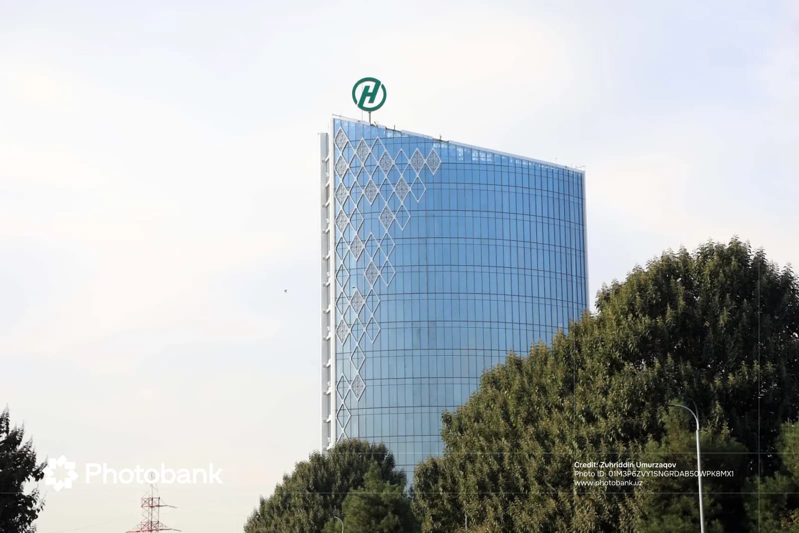 Modern high-rise commercial building exterior with glass facade and geometric decoration