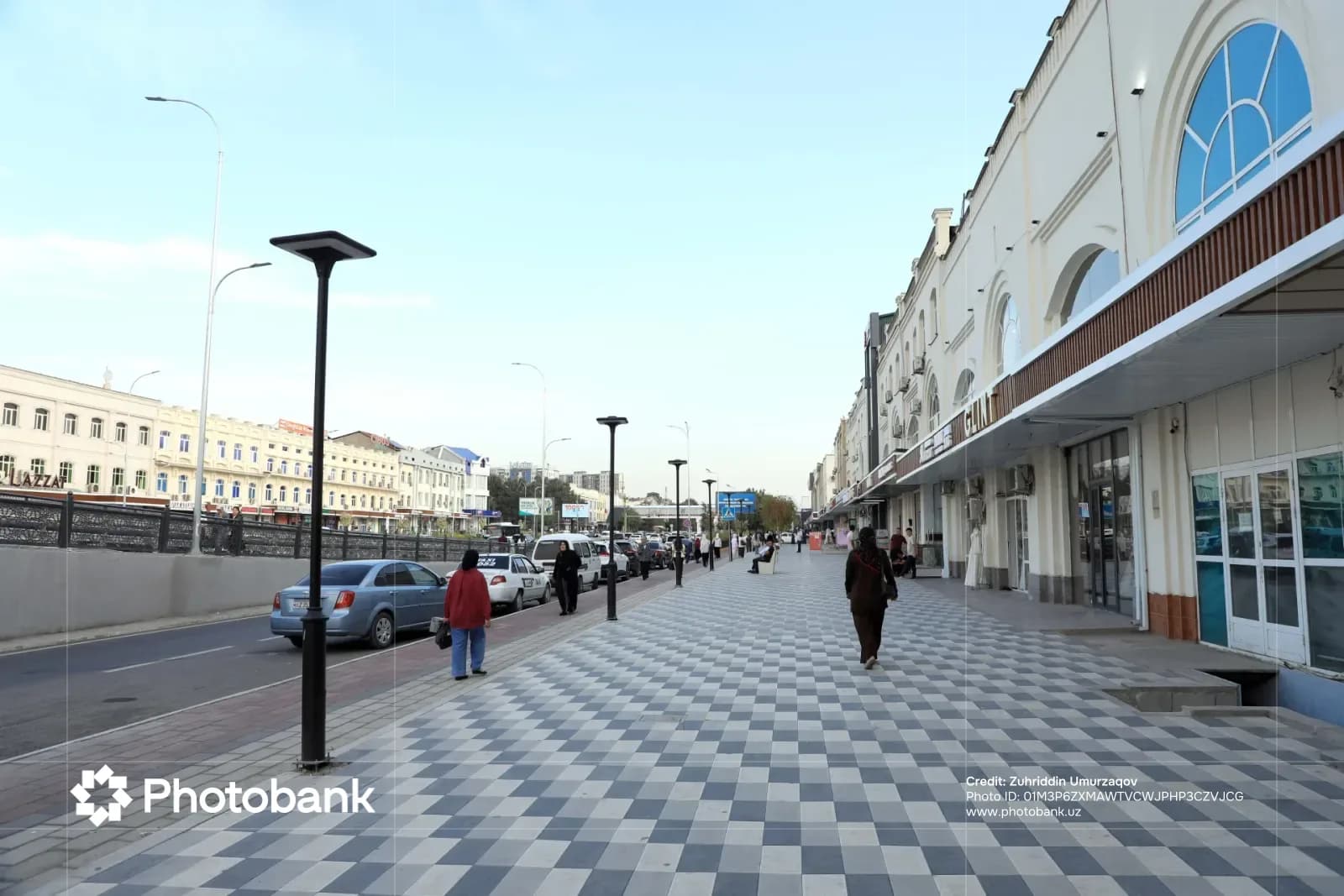 People walking on a tiled pedestrian sidewalk along a city street