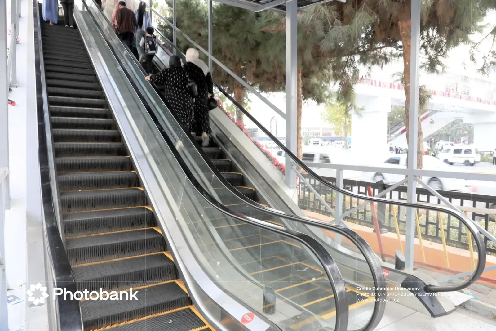 People riding an outdoor escalator