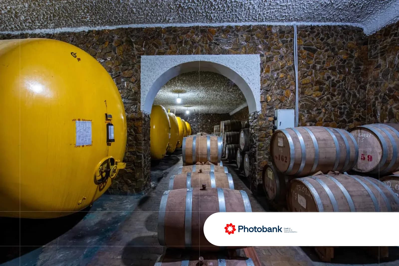 Storage cellar with large yellow tanks and wooden barrels