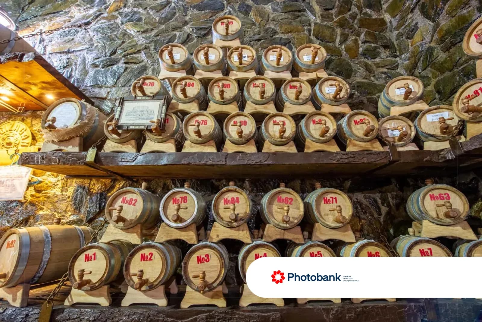 Wooden barrels with taps stacked on stone shelves