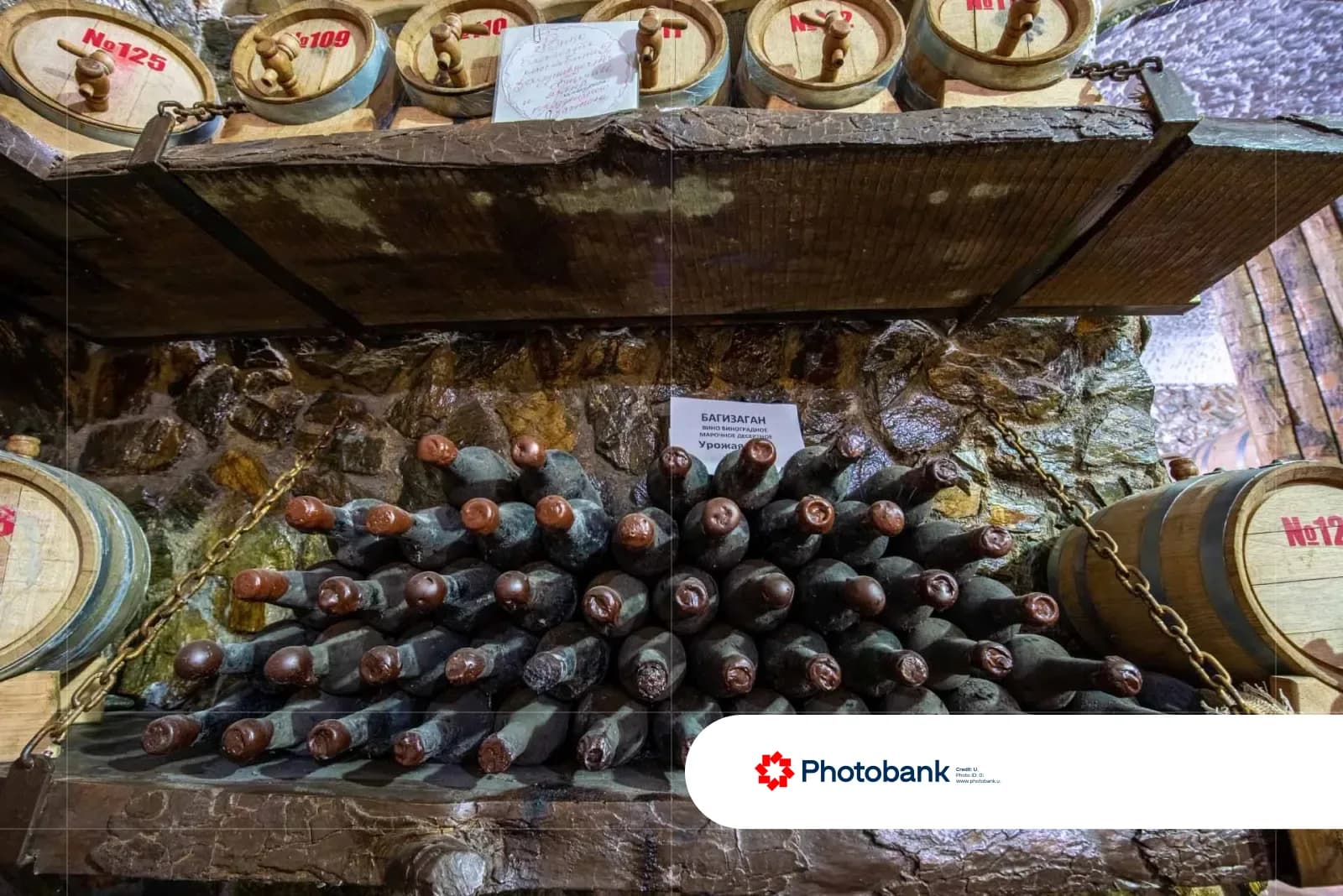 Wine barrels and stacked bottles on cellar shelves