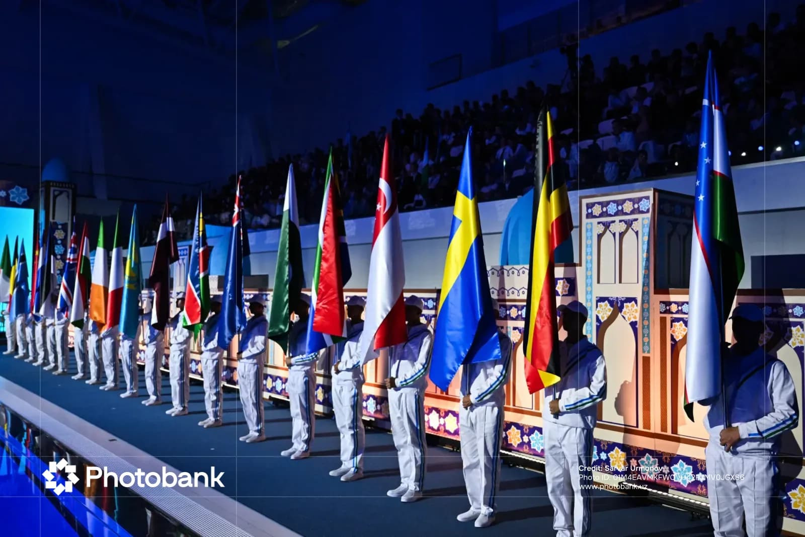 People holding flags in an indoor arena