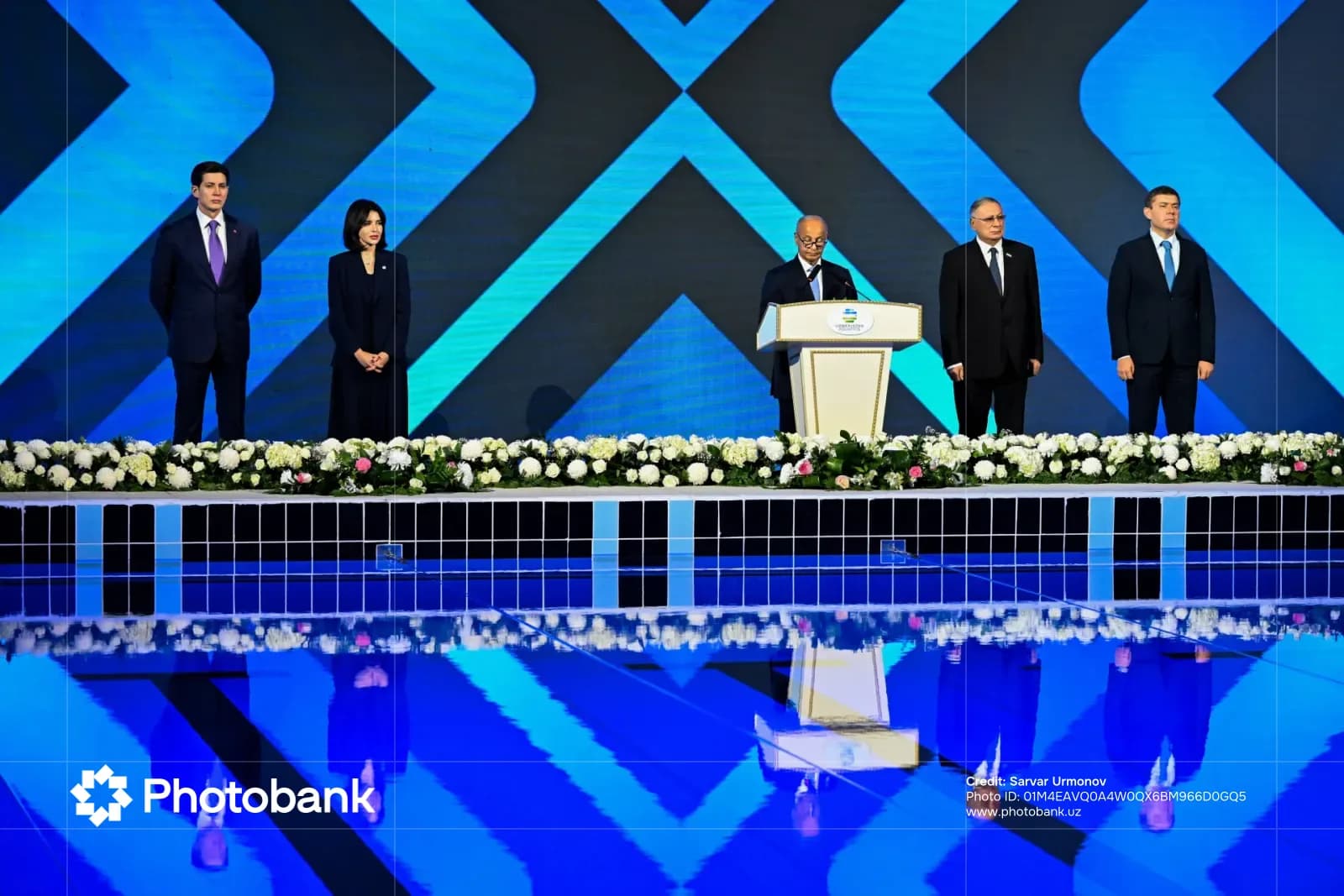 Odil Abdurahmonov speaking at a podium during an event