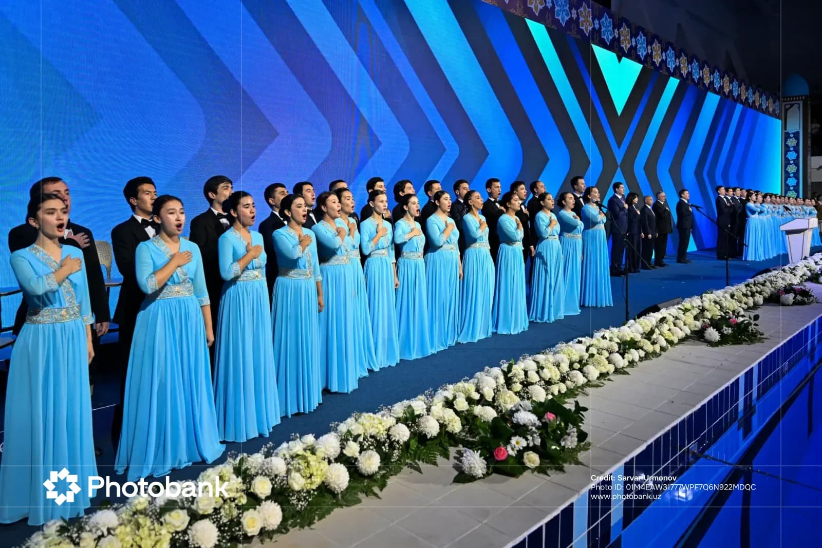 People performing on stage in blue dresses