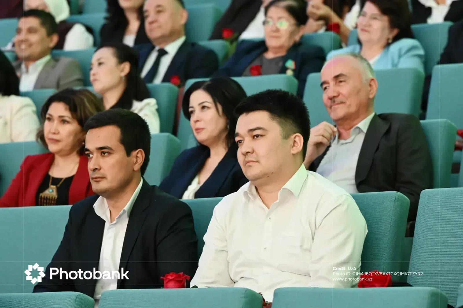 Люди, сидящие в аудитории и внимательно слушающие