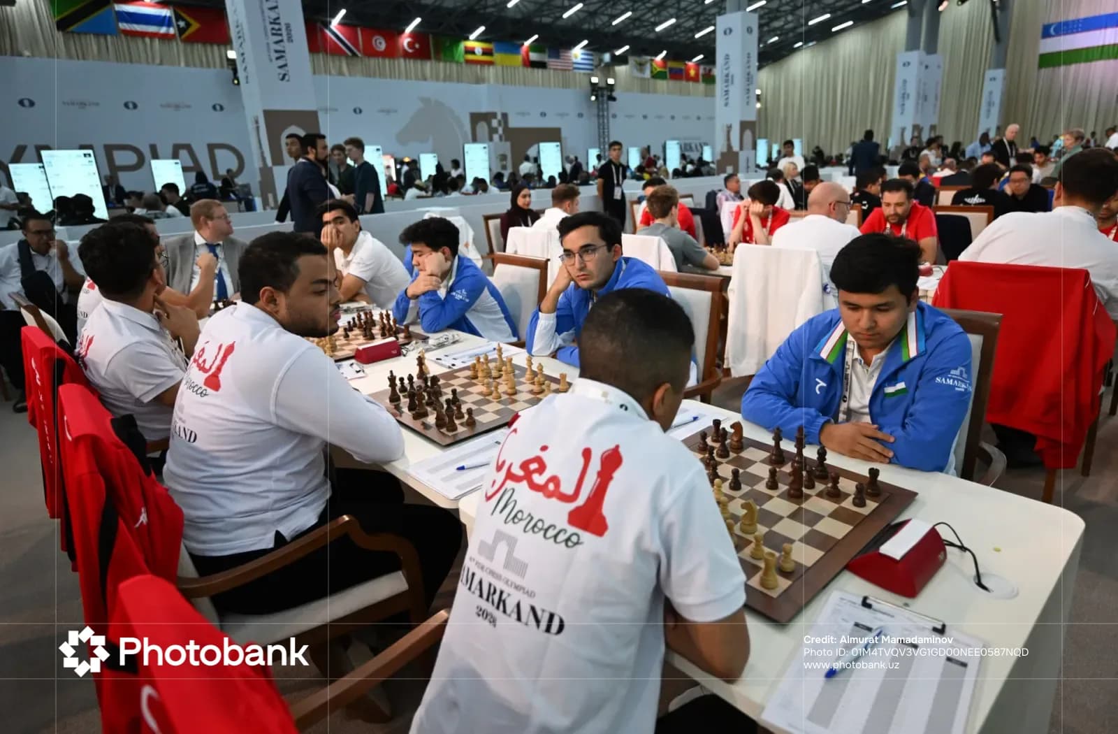 People playing chess at tables in a large hall
